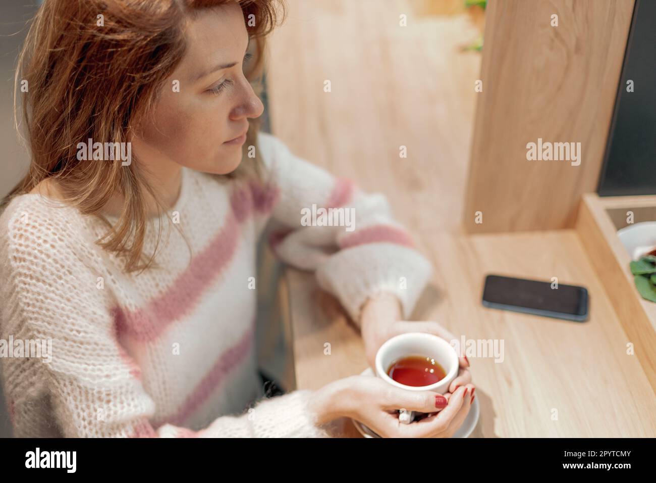 Femme adulte tenant une tasse de thé. Banque D'Images