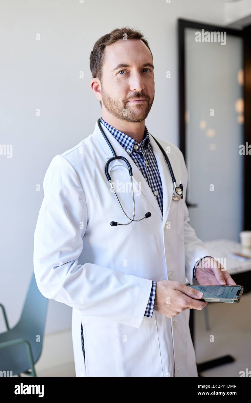 Portrait d'un médecin tenant un smartphone en clinique Banque D'Images