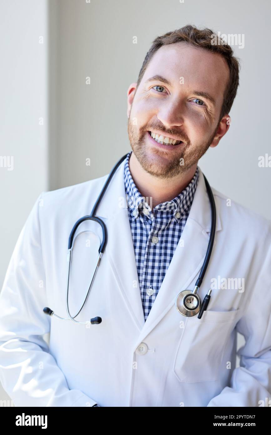 Portrait d'un professionnel de la santé masculin heureux avec stéthoscope en clinique Banque D'Images