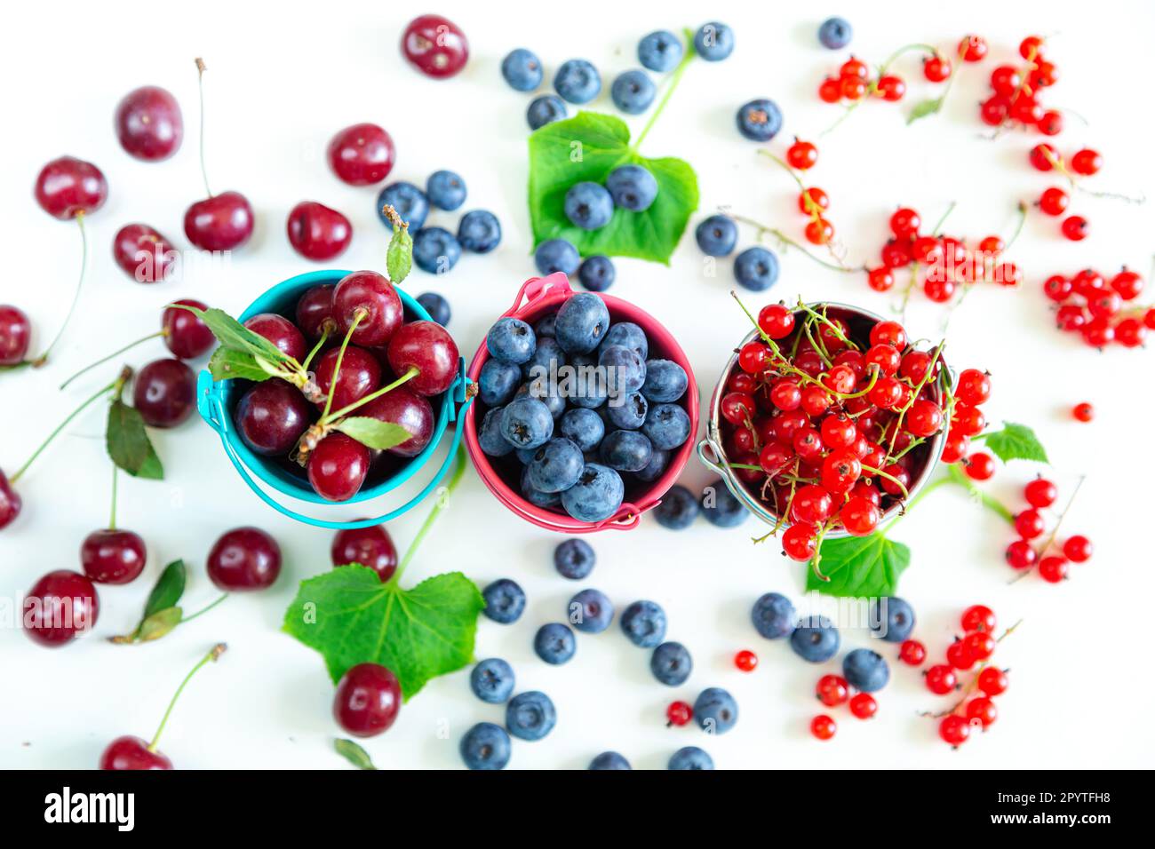 Mélanger les baies fraîches dans de petits seaux. Vue de dessus. Papier peint d'été juteux. Banque D'Images