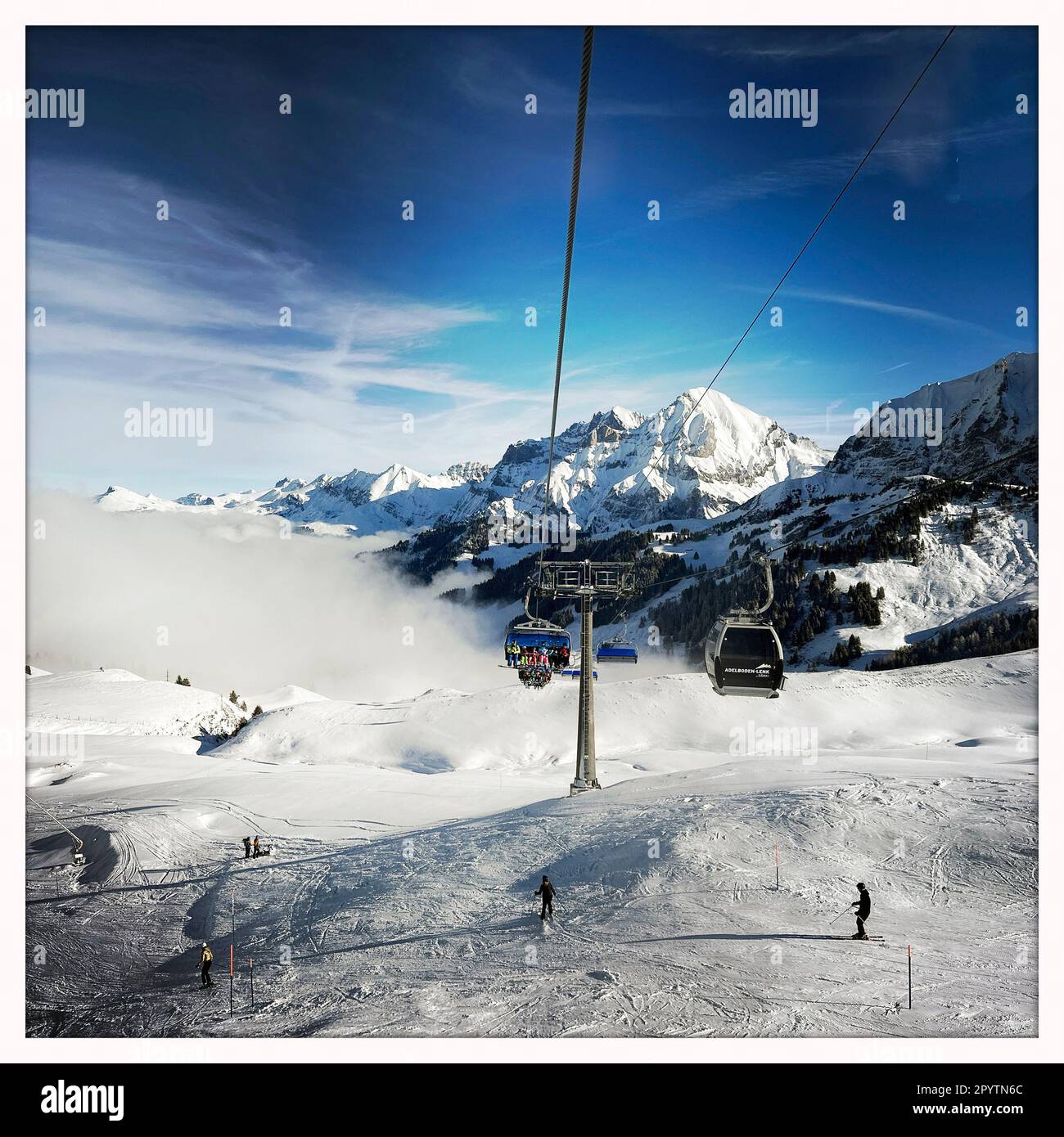 DE LA SÉRIE ADELBODEN téléphérique dans la neige en face du paysage viticole à Adelboden, Oberland bernois, canton de Berne, Suisse. La ville pittoresque d'Adelboden est une idylle suisse dans les Alpes bernoises, des sommets impressionnants, un paysage d'hiver unique, un domaine skiable populaire, des pâturages alpins, cascades jaillissantes, maisons en bois confortables. En raison du changement climatique et de moins en moins de neige, le complexe sportif classique d'hiver se réoriente et la saison estivale devient de plus en plus importante. Photo prise avec iPhone, application Hipstamatic. Banque D'Images