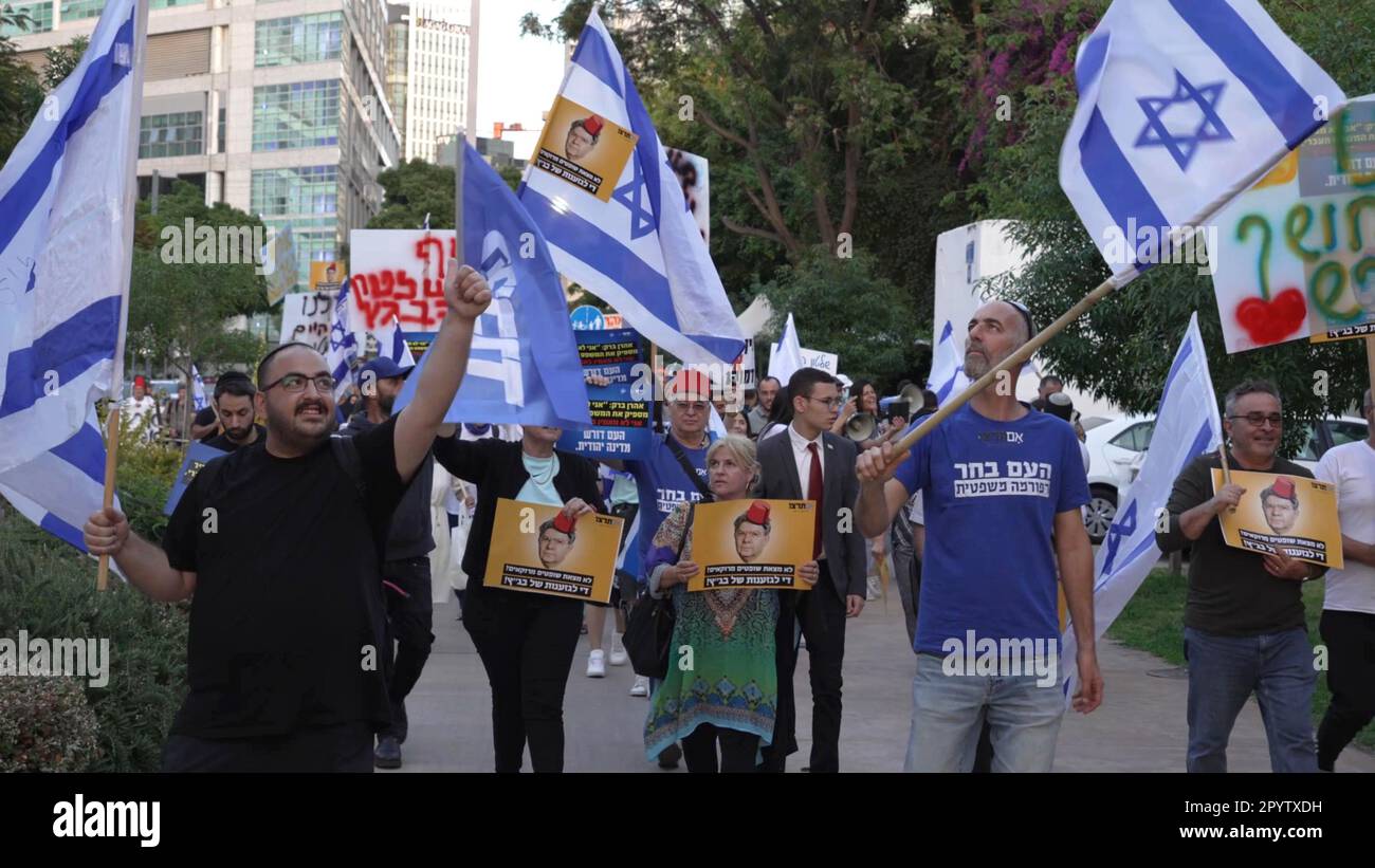 Des manifestants de droite brandisquent des signes avec l'image de l'ancien président de la haute Cour de justice Aharon Barak, avec un chapeau Fès rouge, Porté traditionnellement par les Marocains lorsqu'ils se rendent à une manifestation organisée par des partisans de la réforme et des Juifs marocains près du domicile de l'ancien président de la haute Cour de justice Aharon Barak, En réponse à ses prétentions passées qu'il ne pouvait « trouver un seul » juge marocain ou Mizrahi pour siéger à la Cour suprême de 4 mai 2023 à tel-Aviv, Israël. Banque D'Images