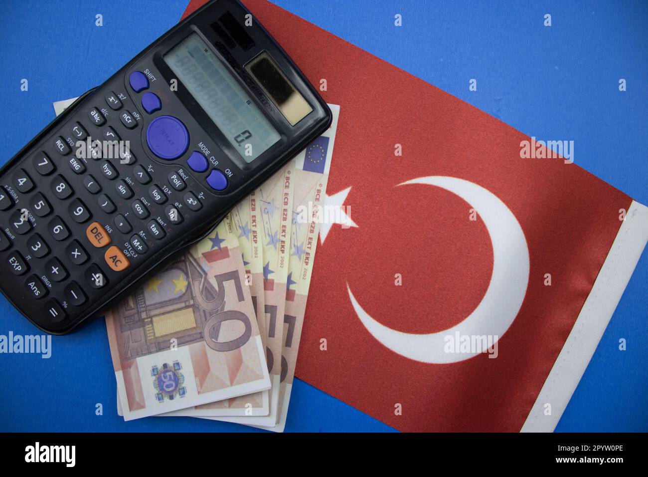 Le drapeau de la Turquie placé sur fond bleu, des euros et une calculatrice. photographié d'en haut. Banque D'Images
