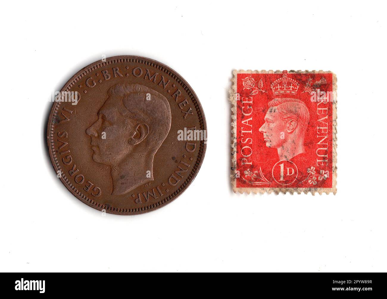 Pièce de monnaie de penny et timbre du règne du roi George VI isolé sur un fond blanc. Banque D'Images