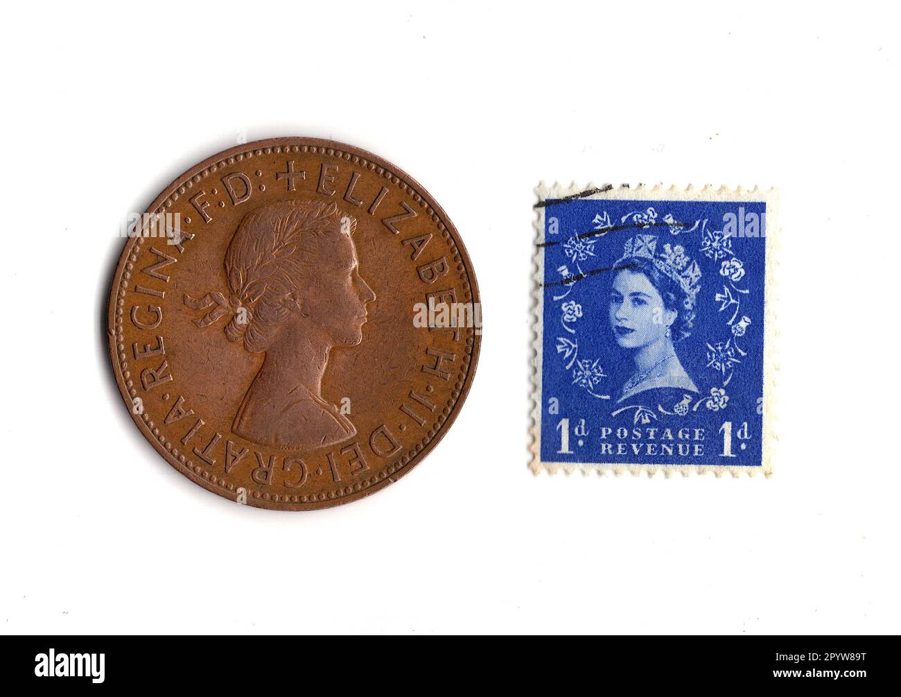 Pièce de monnaie de penny et timbre du règne de la reine Elizabeth II isolé sur un fond blanc. Banque D'Images