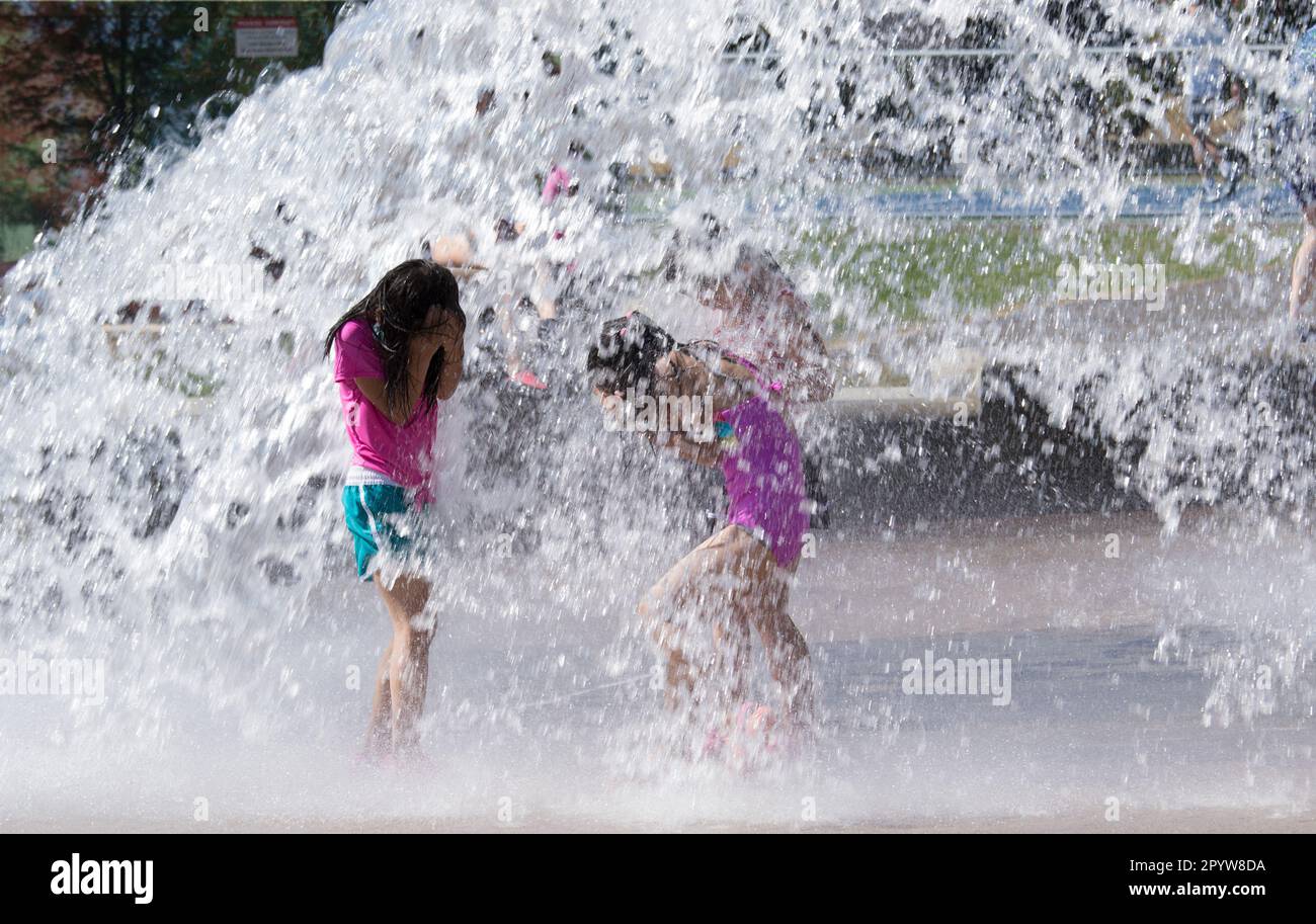 Les enfants jouent avec de l'eau dans un parc sous avertissement de chaleur à Vancouver, en Colombie-Britannique. La température maximale est prévue à 35 degrés Celsius. Banque D'Images