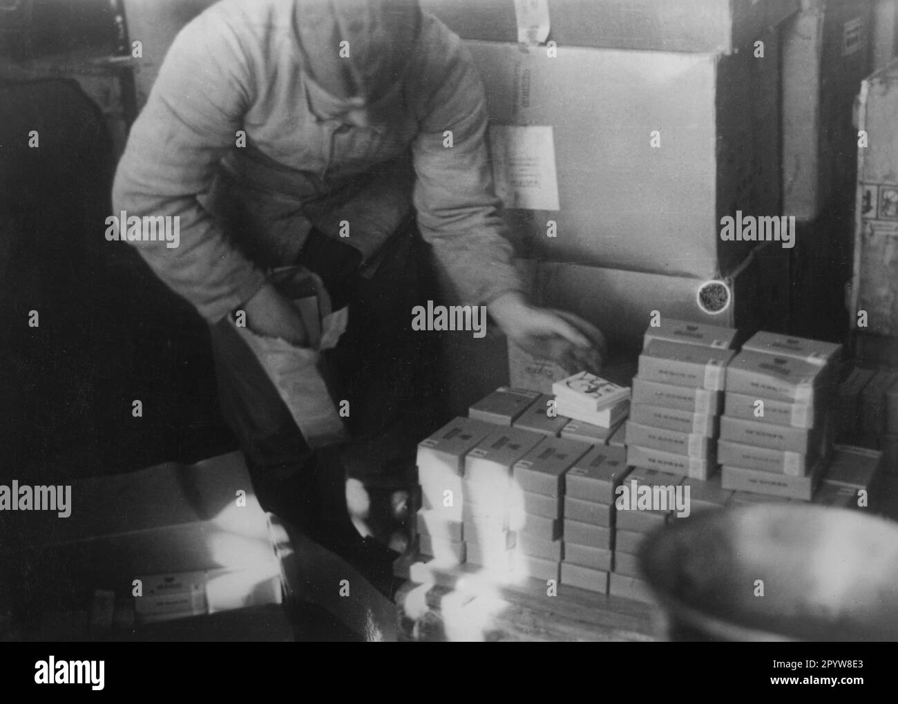 Un soldat en costume de forage trie les paquets de cigarettes dans un dépôt d'approvisionnement près de Krasnograd près de Kharkov (Kharkiv). Photo: Kintscher [traduction automatique] Banque D'Images
