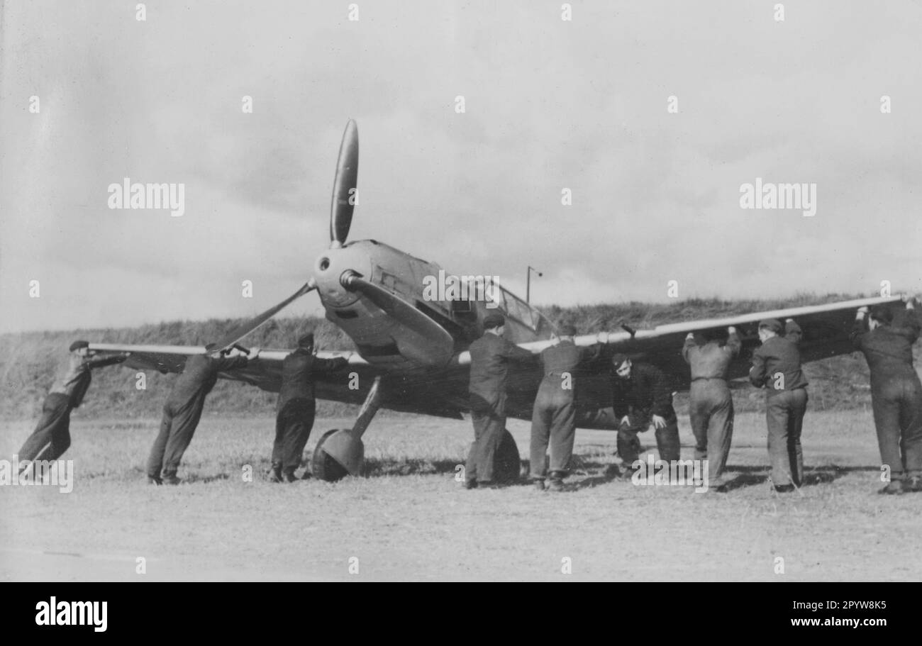 Des hommes d'équipage au sol poussent un combattant allemand moi 109 sur un terrain d'aviation pendant la bataille d'Angleterre. Photo: Schubert [traduction automatique] Banque D'Images