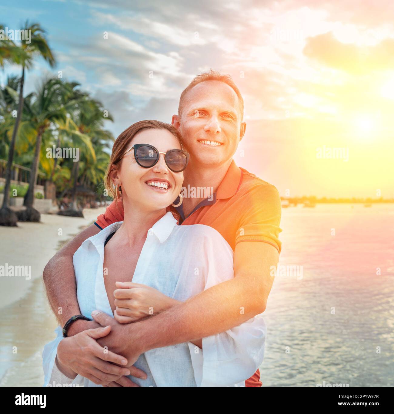 Couple amoureux s'embrassant sur la plage de sable exotique pendant qu'ils ont une promenade en soirée au bord du trou-aux-Biches sur l'île Maurice. Relationsh des personnes Banque D'Images