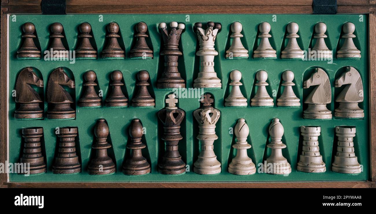 Une collection de pièces d'échecs disposées dans une caisse en bois Banque D'Images