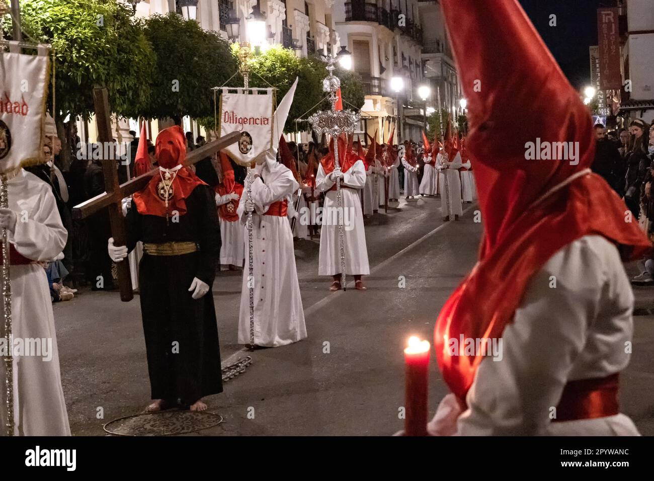 Les pénitents à capuche marchent pieds nus avec des chaînes comme ils portent des croix en bois pendant la procession silencieuse de minuit marquant le Vendredi Saint à la semaine Sainte ou Semana Santa, 6 avril 2023 à Ronda, Espagne. Ronda, établie pour la première fois au 6th siècle avant Jésus-Christ, organise des processions de la semaine Sainte depuis plus de 500 ans. Banque D'Images