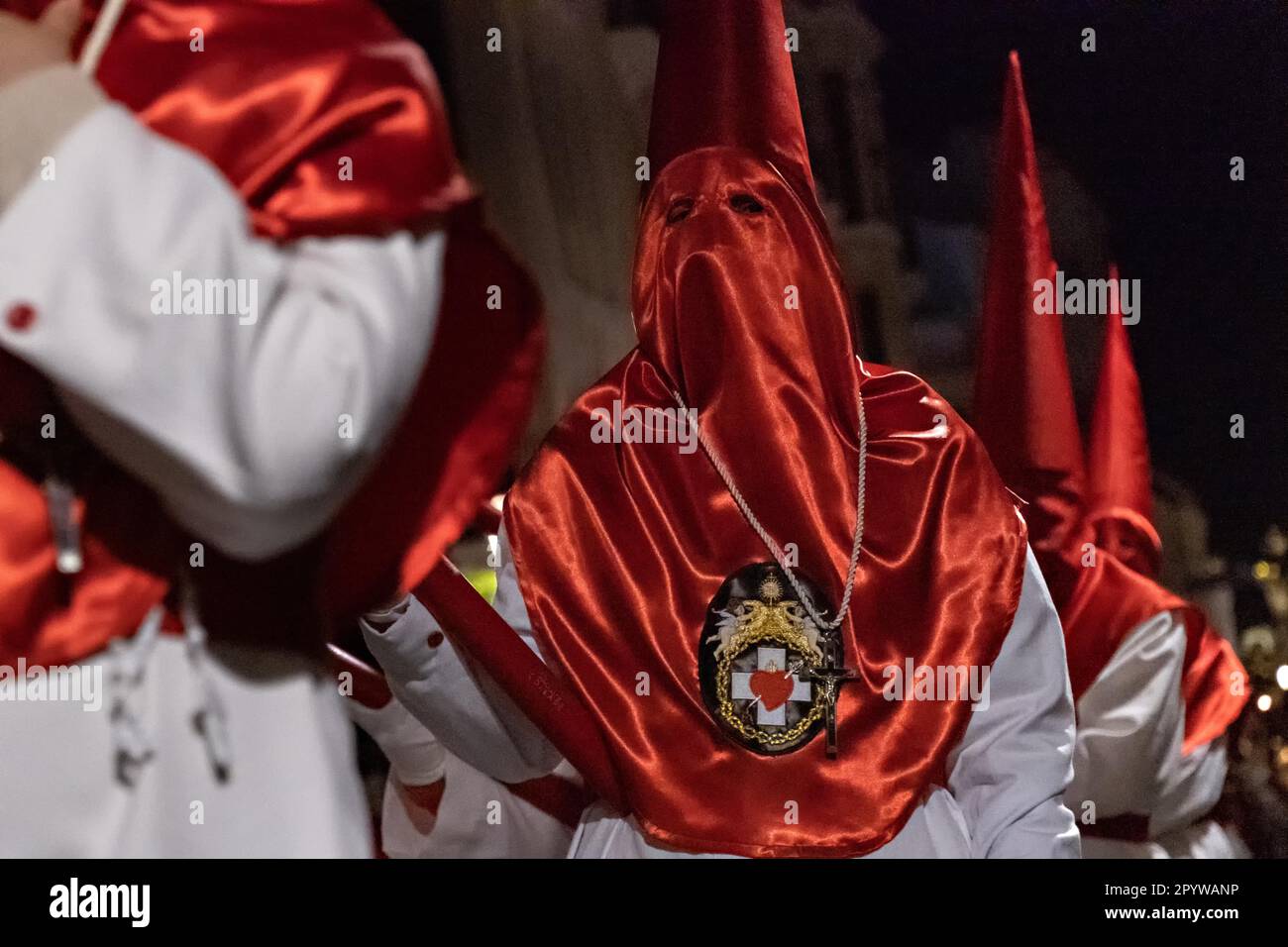 Les Cofradias portant des capuches rouges en forme de cône marchent dans les rues pendant la procession silencieuse de minuit marquant le Vendredi Saint à la semaine Sainte ou Semana Santa, 6 avril 2023 à Ronda, Espagne. Ronda, établie pour la première fois au 6th siècle avant Jésus-Christ, organise des processions de la semaine Sainte depuis plus de 500 ans. Banque D'Images