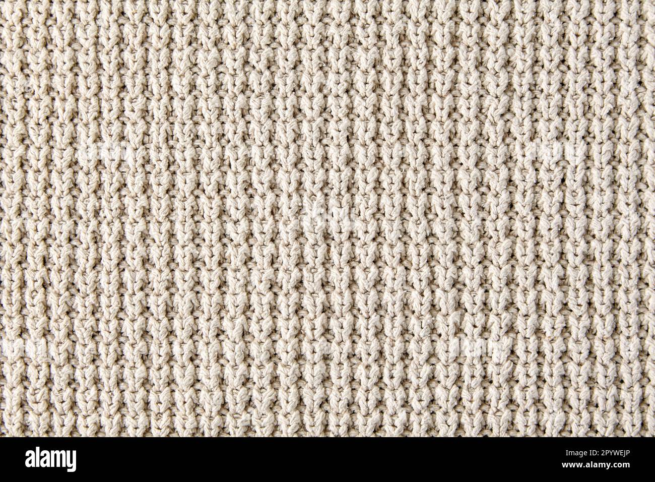 Fragment de vêtements tricotés beiges de tricot rugueux. Arrière-plan du design, maquette Banque D'Images