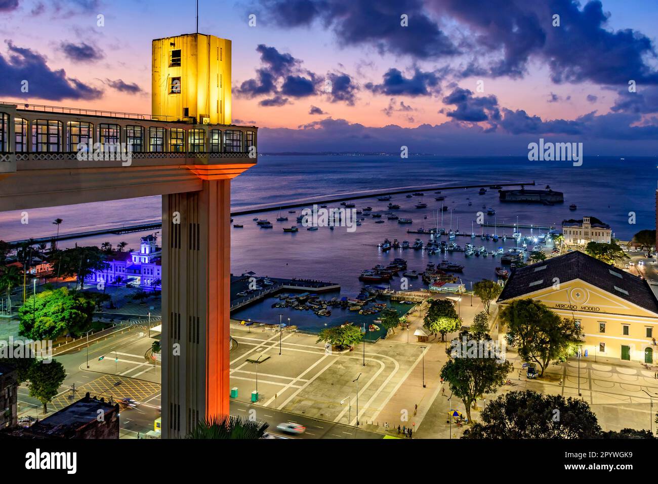 Ascenseur Lacerda illuminé au crépuscule et avec la mer et les bateaux en arrière-plan dans la ville de Salvador, Bahia, Brésil Banque D'Images