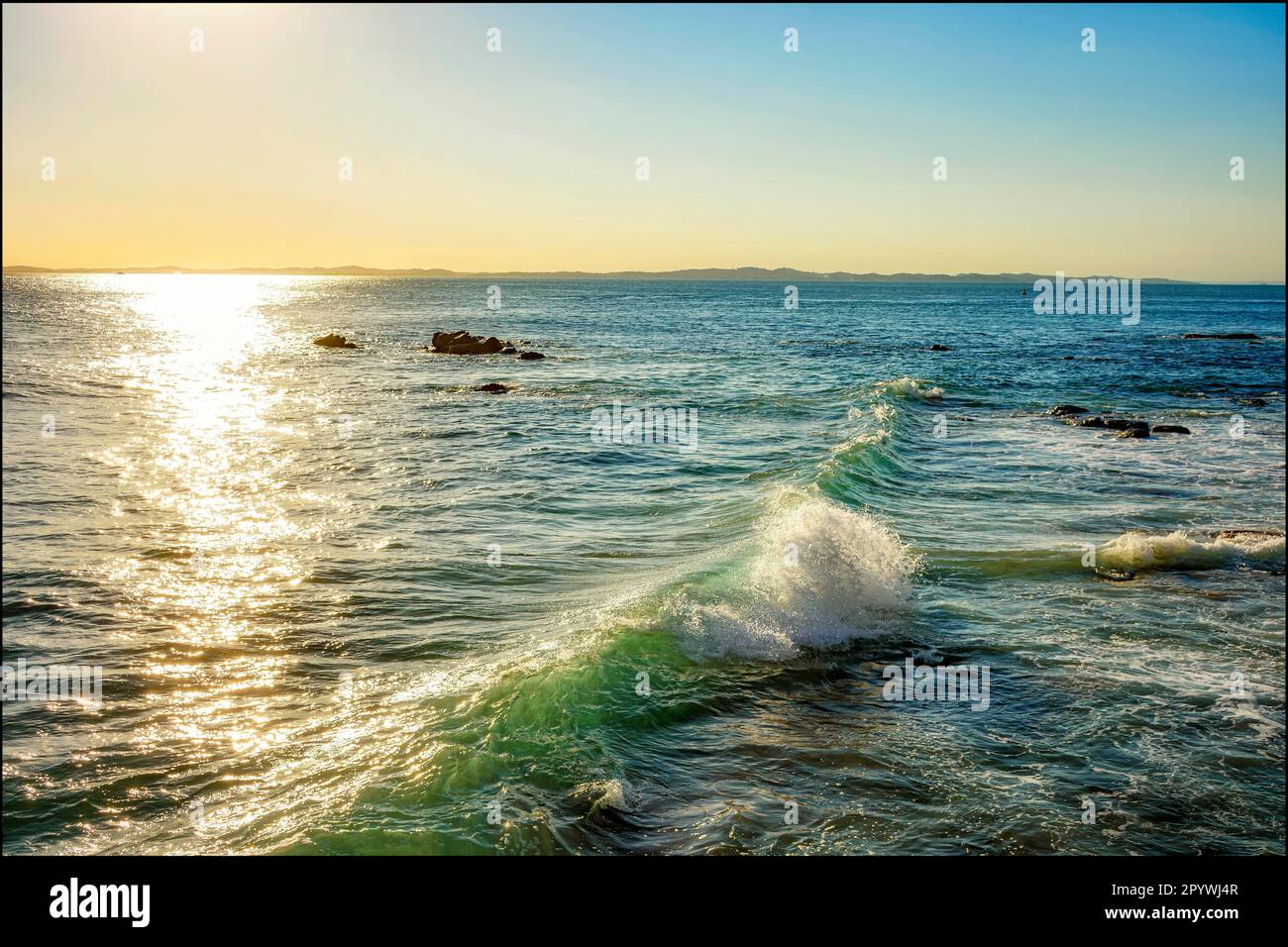 Coucher de soleil sur les eaux de la mer dans la ville de Salvador à Bahia avec de petites vagues se brisant le long des rochers, le Brésil Banque D'Images