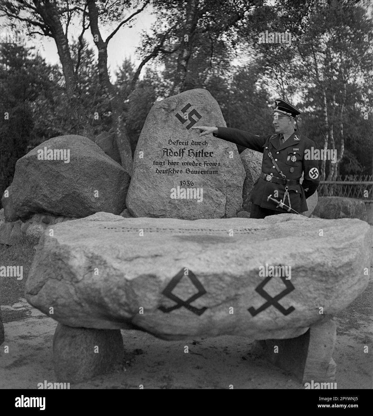 'Autel et pierres de dédicace (blocs erratiques) sur la place Landtag à Hösseringen près de Suderburg dans la lande de Lüneburg. Sur l'autel est écrit: ''au service du peuple allemand, j'épuise ma force.''. Au fond de l'autel se trouvent deux runes odales germaniques, elles signifient: Possession d'héritage, possession ancestrale. Sur le rocher derrière il y a une croix gammée, inscription: ''libérée par Adolf Hitler la paysannerie allemande libre se réunit ici encore 1936''. La photo a été prise à l'occasion de l'inauguration de la place Landtag par les socialistes nationaux sur 28 juin 1936. [automatisé Banque D'Images