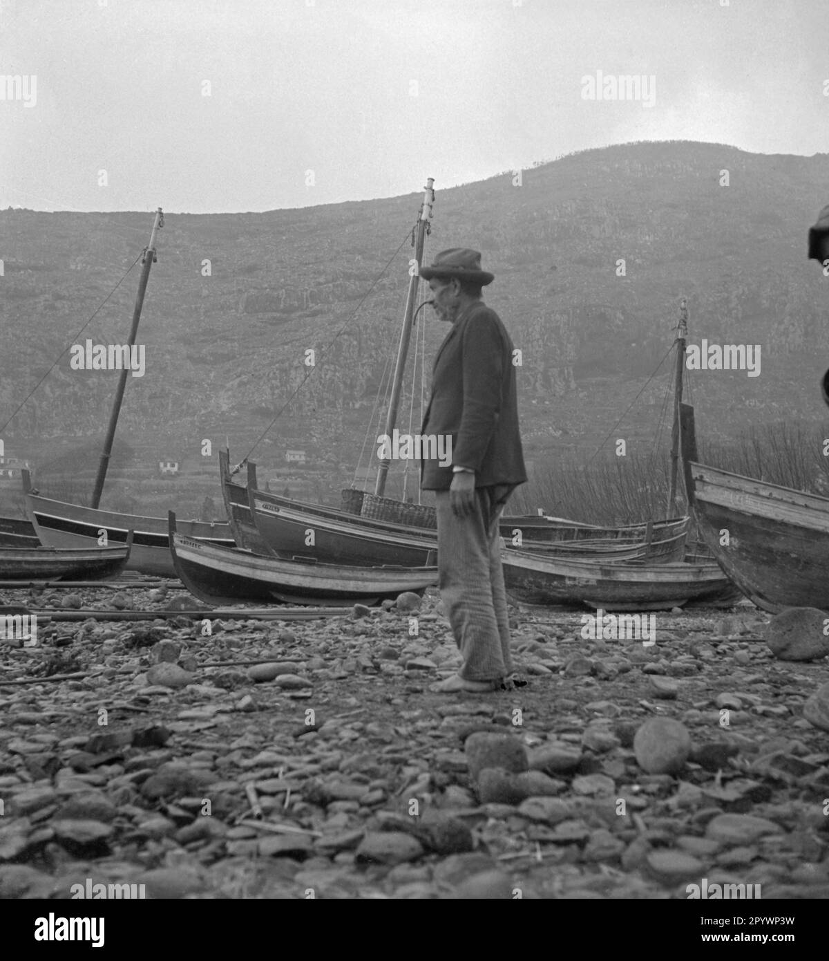 Homme debout sur la plage de Madère. En arrière-plan sont des bateaux à voile. Banque D'Images