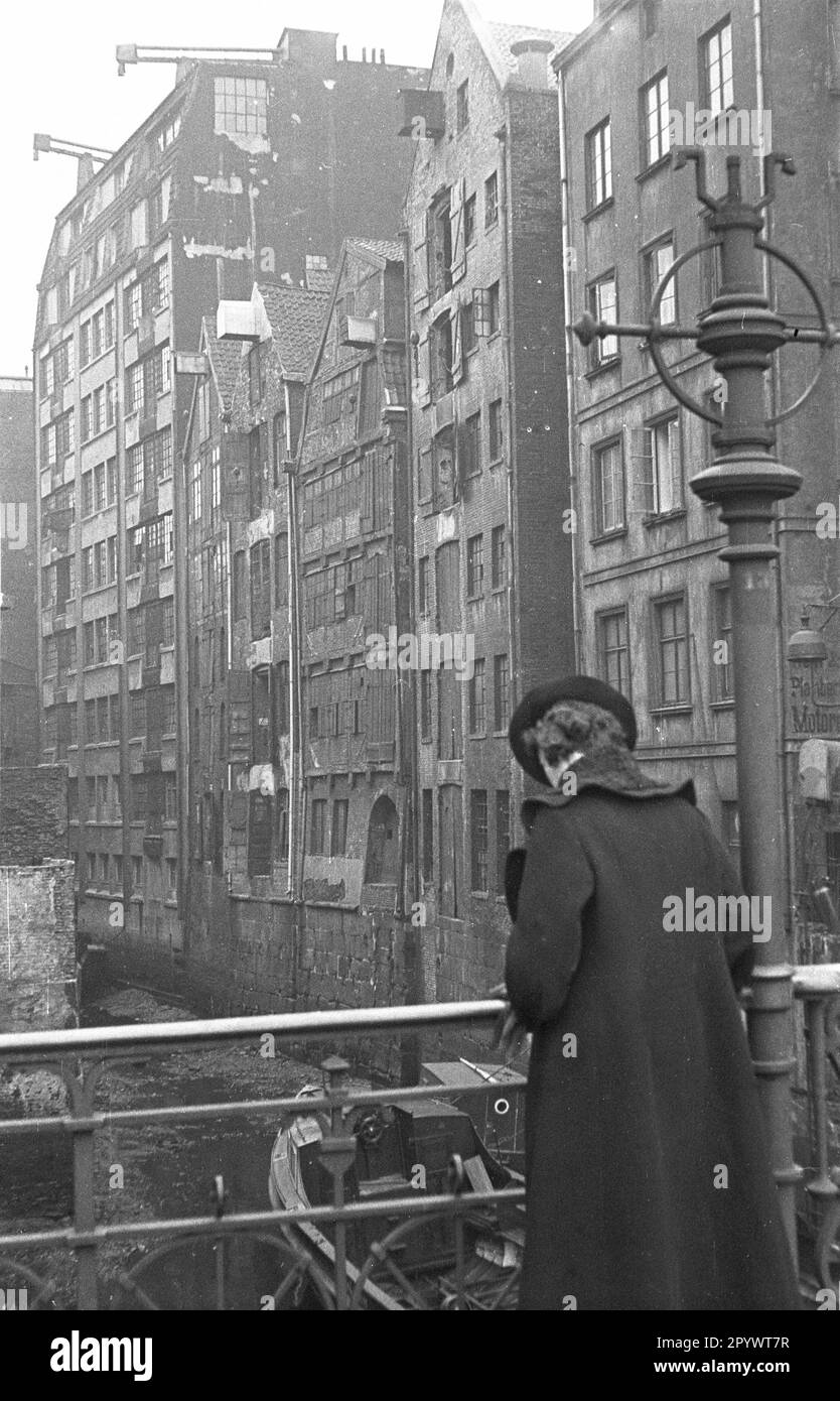 Une femme sur un pont au-dessus d'un soi-disant dike, une douve de l'Elbe dans le Speicherstadt Hambourg. Banque D'Images