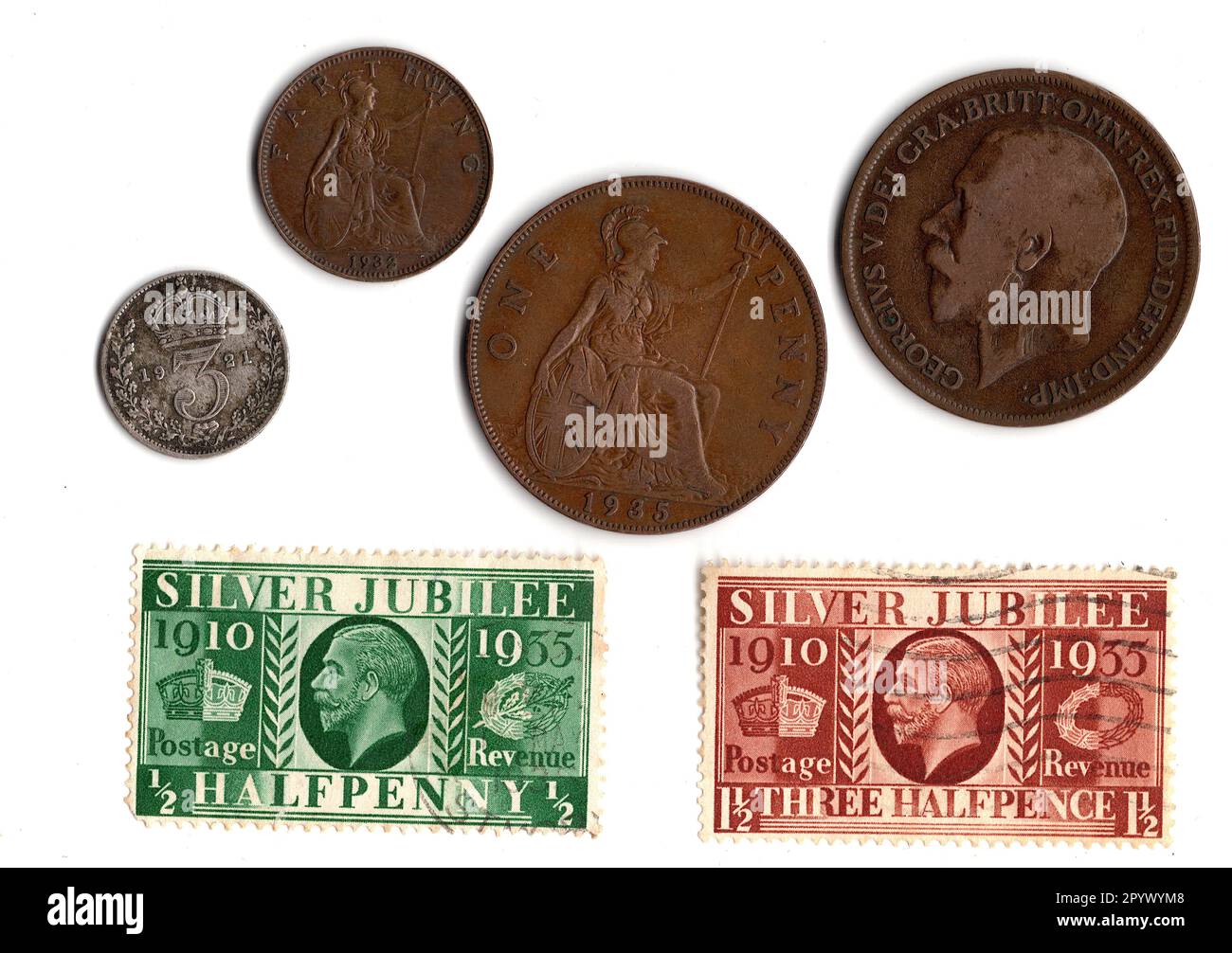 Pièces de monnaie vintage et timbres du règne du roi George V isolés sur fond blanc. Banque D'Images