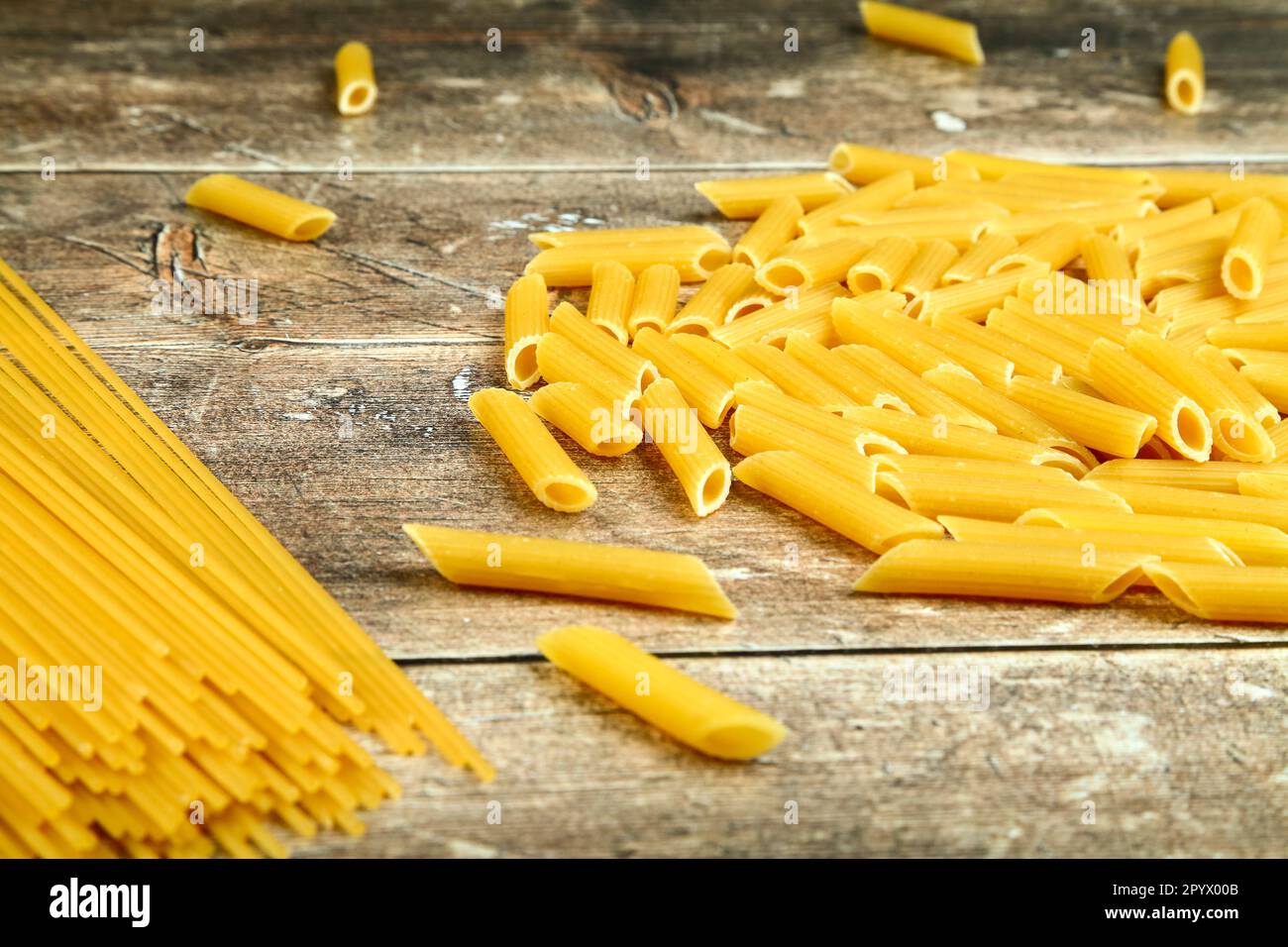 Séchez les pâtes non cuites sur une table de cuisine en bois Banque D'Images