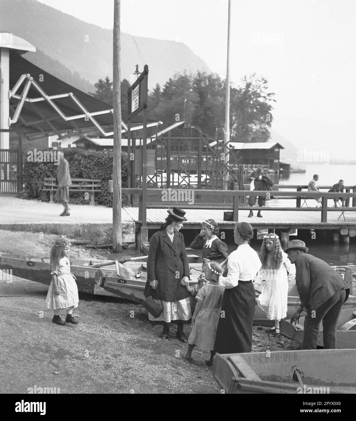 Personnes sur les bateaux sur la rive du lac Zell. En arrière-plan un café et un bateau amarre place. La famille est sur le chemin d'une rue Fête de Mary à Zell. Banque D'Images