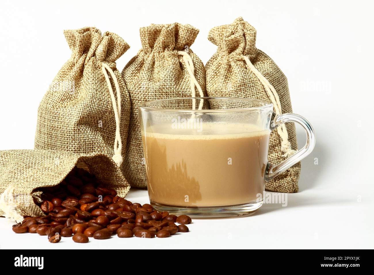 Tasse de café frais avec sachets de grains de café crus Banque D'Images