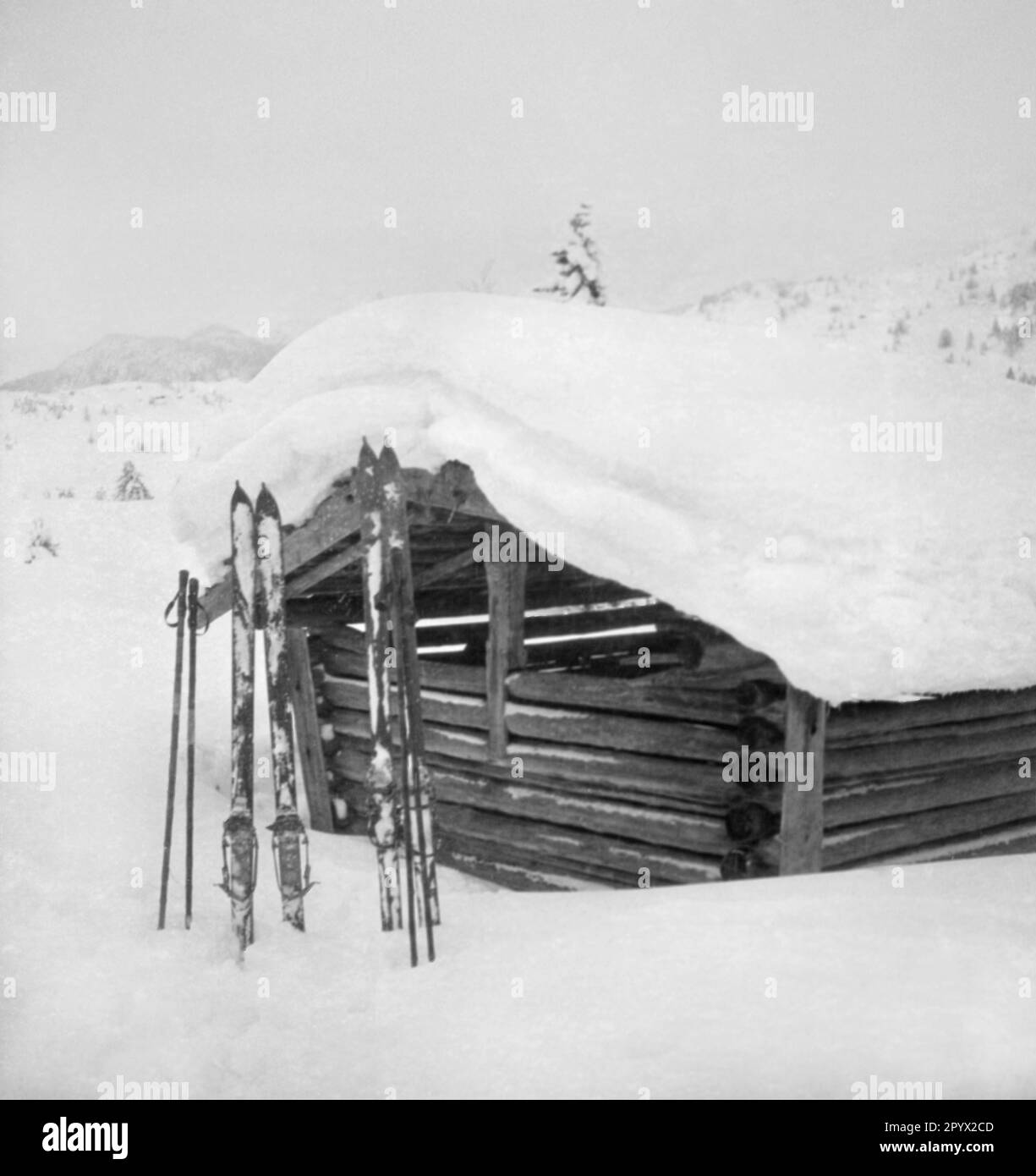 Une cabane enneigée près de Garmisch. Deux paires de skis sont en face de lui dans la neige d'un mètre de hauteur. Photo non datée, probablement à la mi-1930s. Banque D'Images