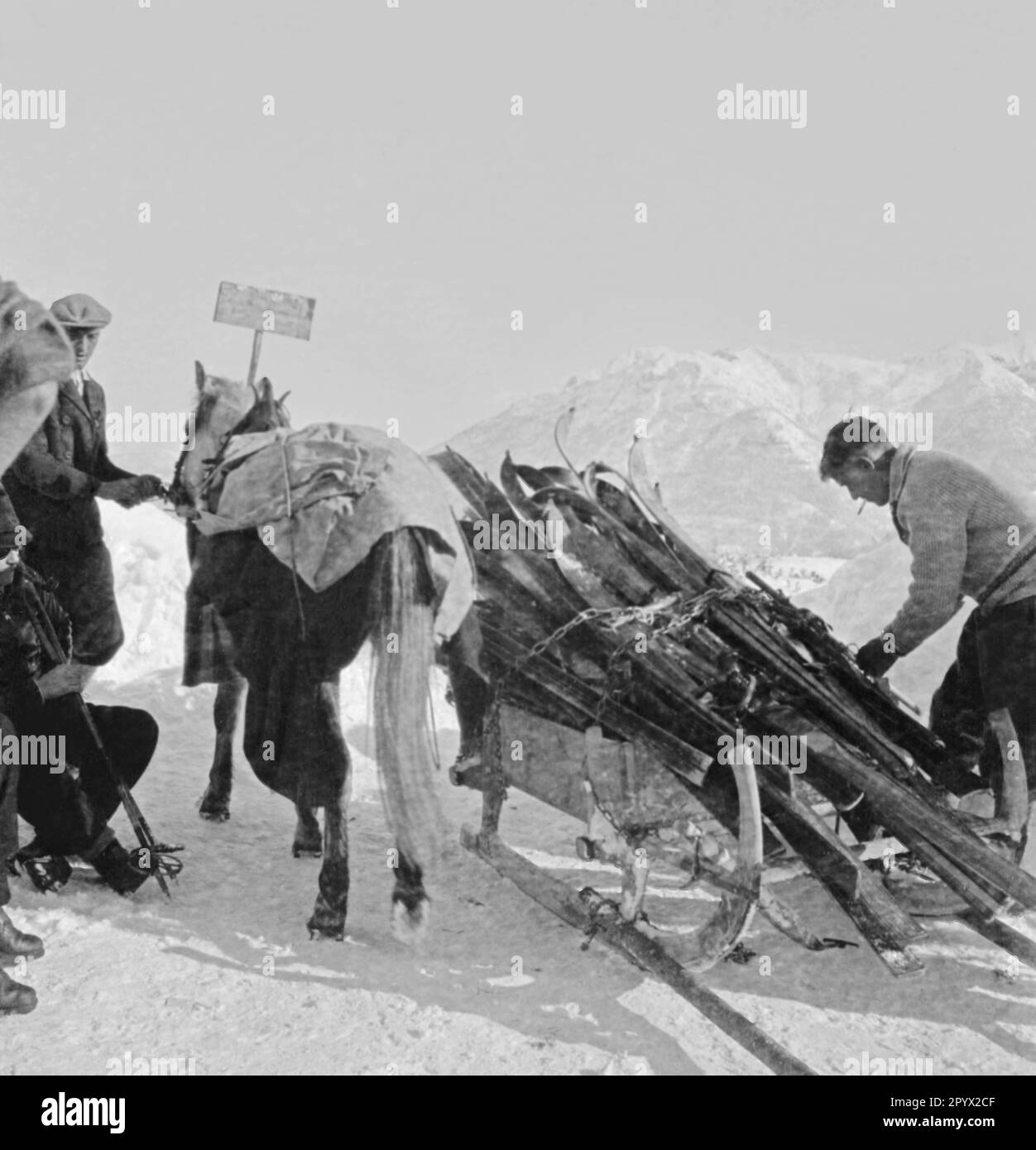 Un traîneau tire l'équipement des participants vers le haut de la montagne. Photo non datée, probablement à la mi-1930s. Banque D'Images
