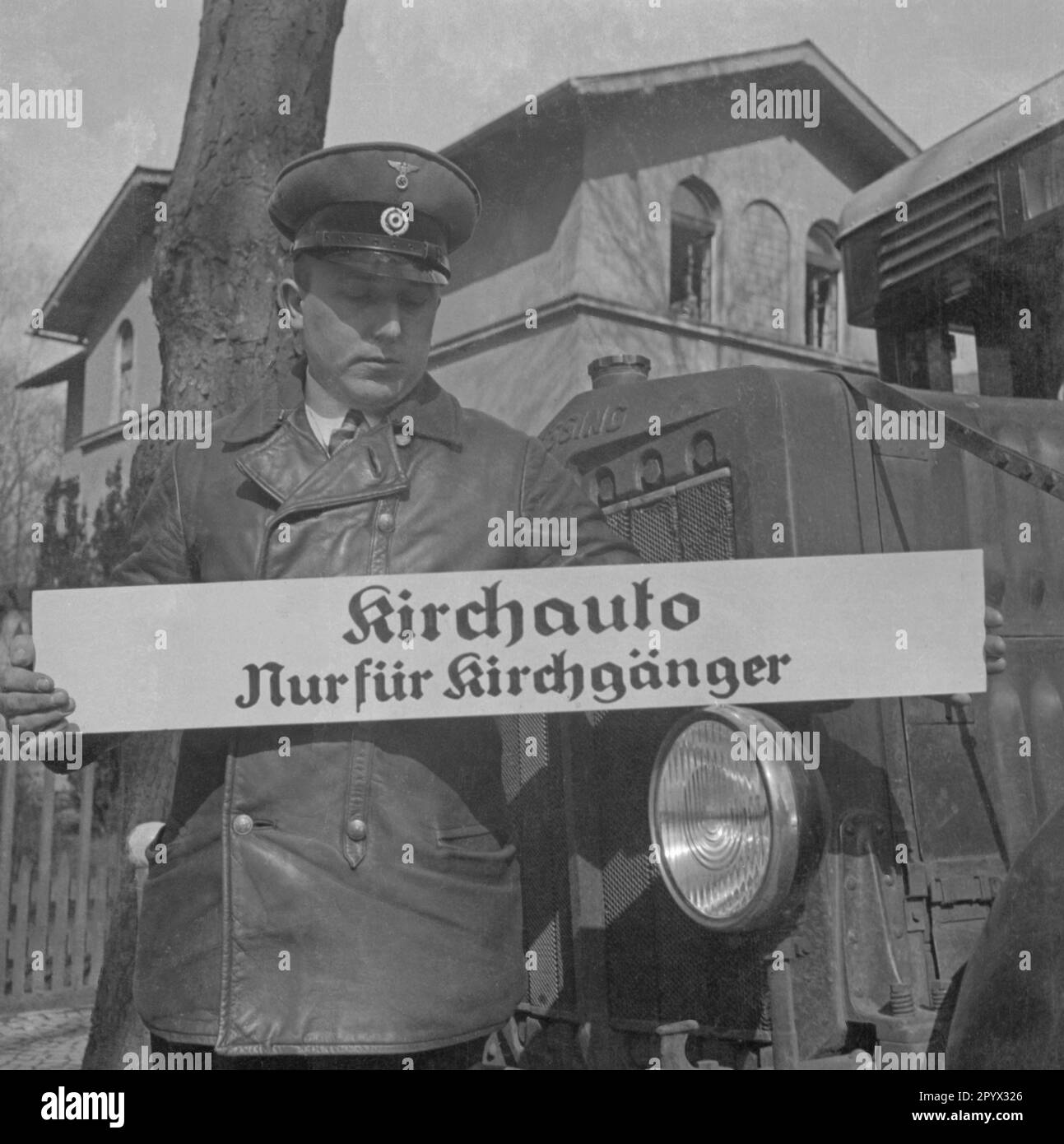 'En 1930s, des voyages en bus ont été organisés spécifiquement pour la présence de l'église. Ici, un chauffeur de bus tient le panneau avec l'inscription: ''voiture de l'église seulement pour les churchgoers''. Derrière lui se trouve un bus de la société Buessing AG (photo non datée). Banque D'Images