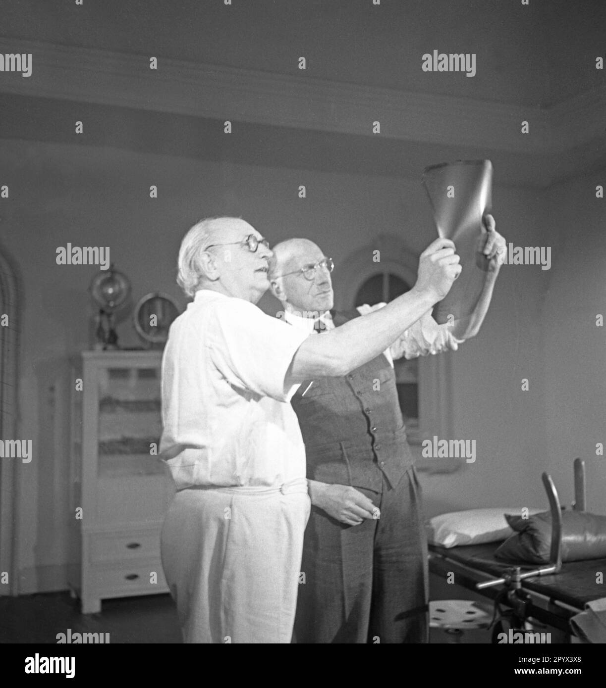 Les professeurs Ferdinand Sauerbruch (à droite) et Julius Jungblut (à gauche) examinent une radiographie à la clinique privée gérée conjointement à Berlin-Grunewald. Banque D'Images