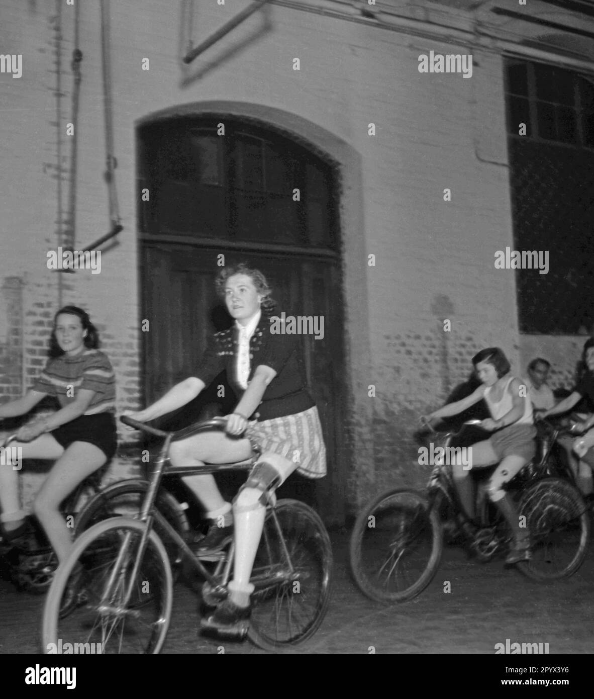 Photo non datée d'un groupe de femmes et de filles handicapées faisant un exercice de cyclisme dans une salle de sport à Berlin, probablement Berlin-Ouest, 1950. Les femmes portent des vêtements de sport et ont des jambes artificielles. Banque D'Images