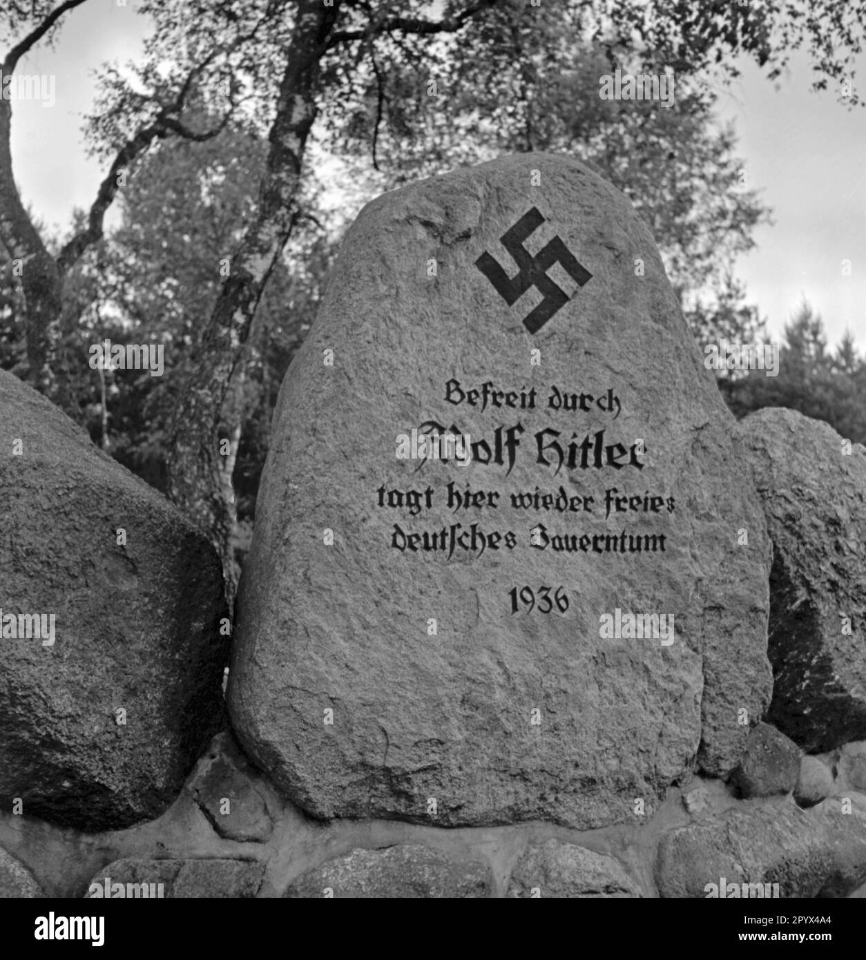'Photo d'une pierre commémorative (erratique glaciaire) à ??la Landtagsplatz à Hoesseringen près de Suderburg dans la Heath de Lueneburg. Sur l'erratique glaciaire se trouve une swastika avec l'inscription: ''libérée par Adolf Hitler, la paysannerie allemande libre se réunit à nouveau, 1936''. La photo a été prise à l'occasion de l'inauguration de la Landtagsplatz par les socialistes nationaux sur 28 juin 1936. Banque D'Images