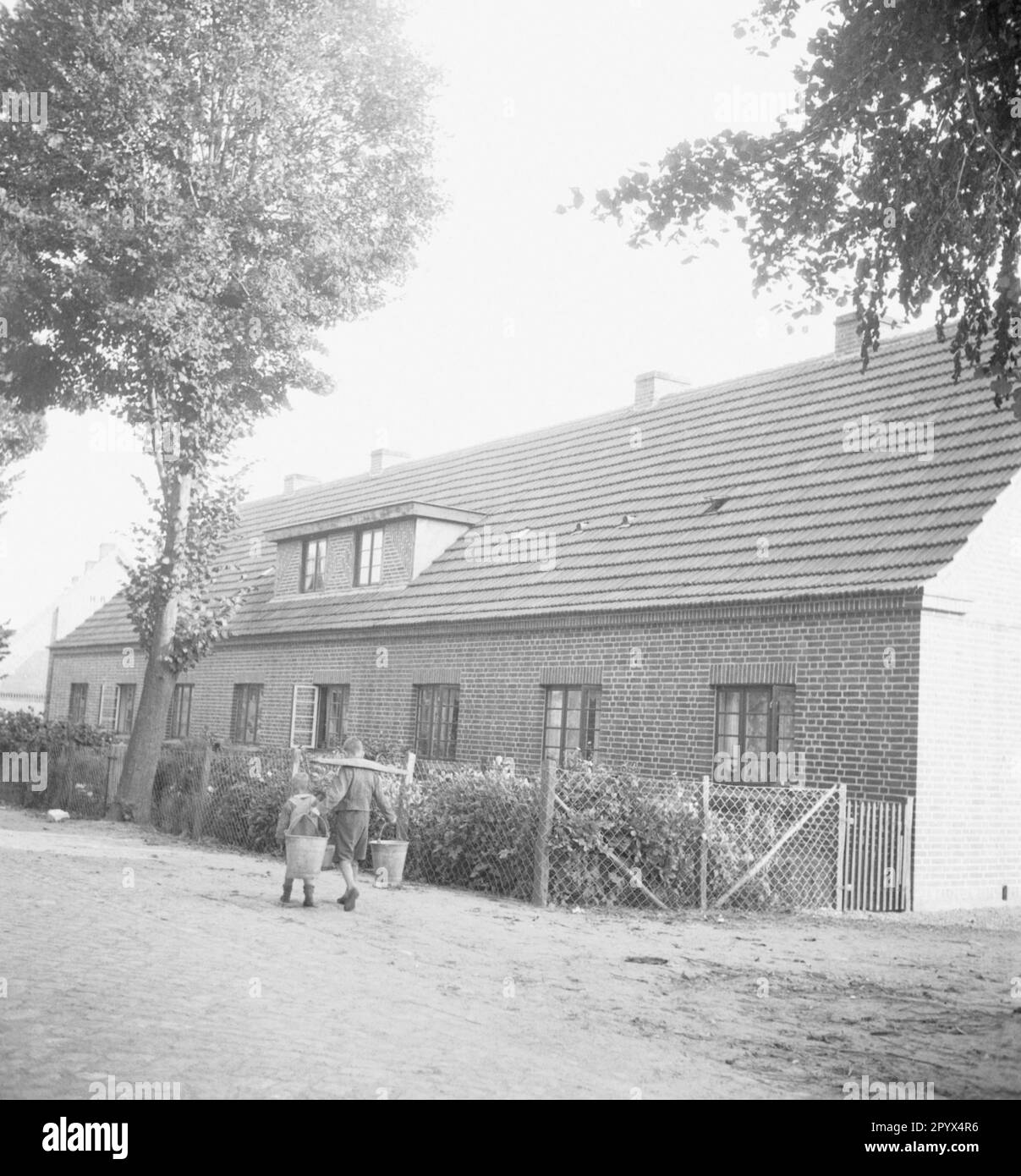 Deux garçons apportent de l'eau près de Neustrelitz. Le plus grand porte un joug avec deux, le plus petit garçon avec un seau. Photo non datée. Banque D'Images