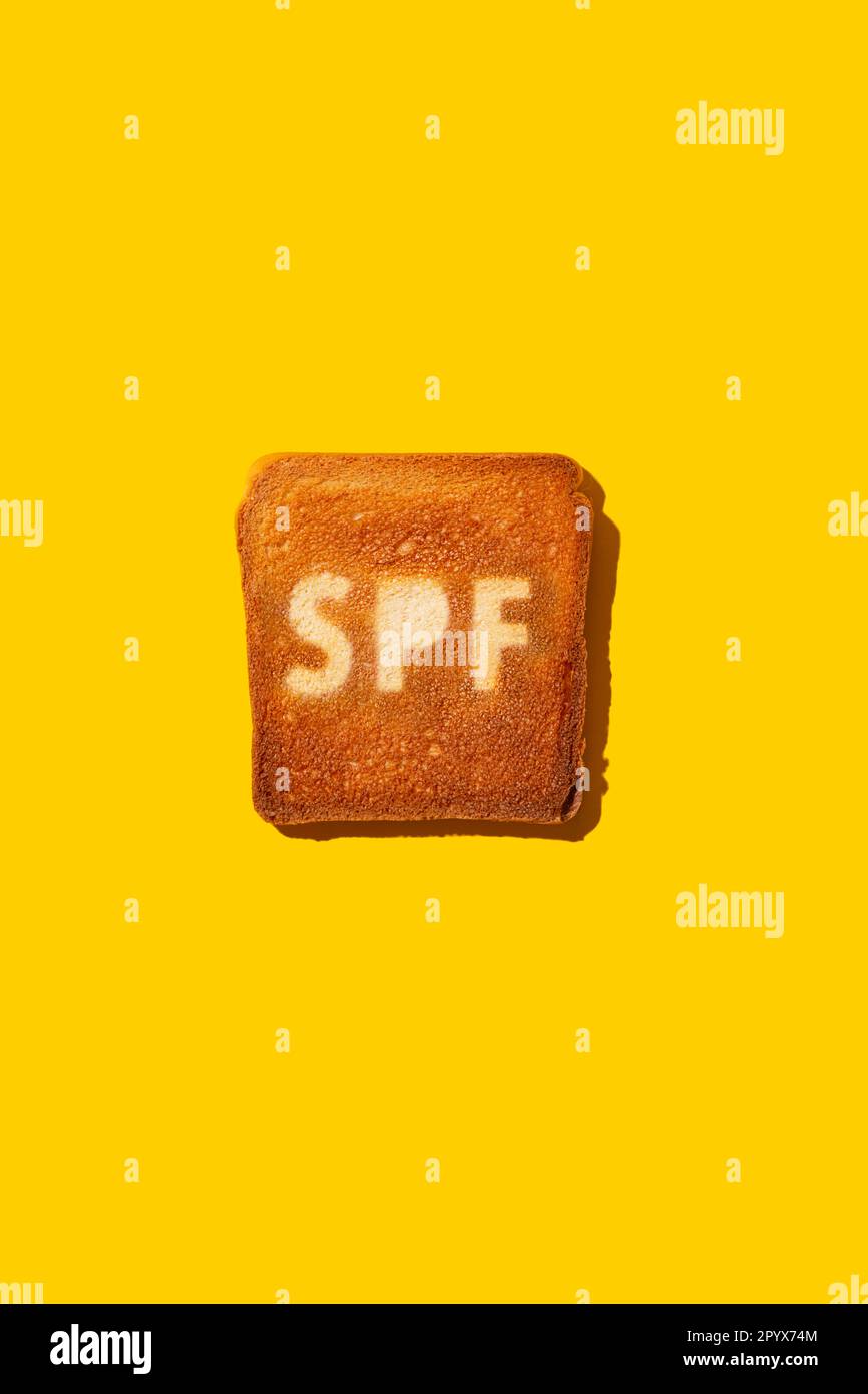 Concept de crème SPF sur pain grillé. Arrière-plan jaune. Banque D'Images