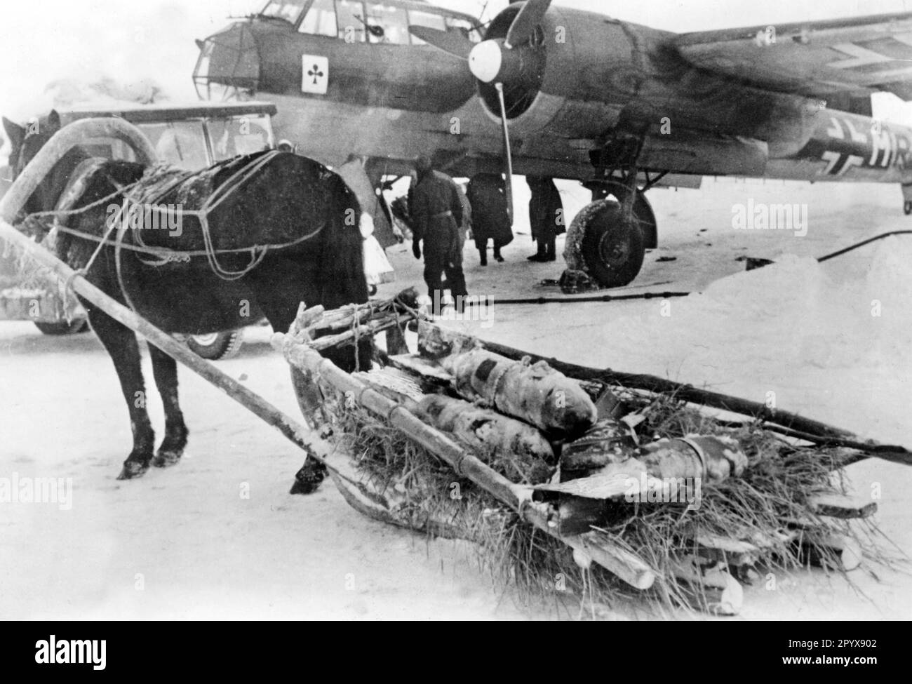 Junkers Ju 88 avion de chasse du Fighter Squadron 3 (ace de clubs sur le rempart) sur un terrain d'aviation dans la section centrale du Front de l'est en novembre 1942. Un traîneau de Panjes apporte la charge de la bombe de l'avion. [traduction automatique] Banque D'Images