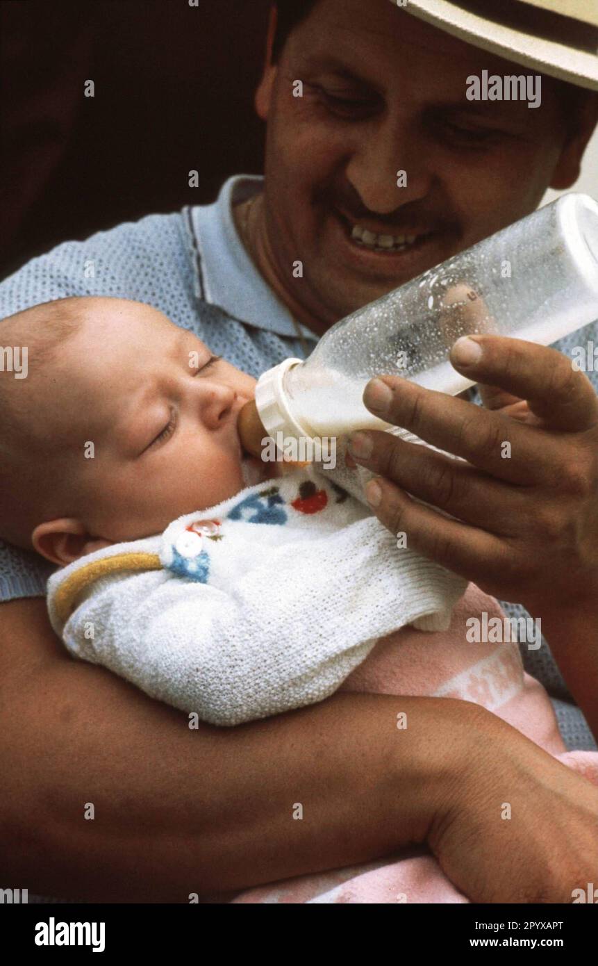 Date de la photo: 10.08.1999 Un père donne la bouteille à son enfant.  Photo: Ralf Gerard/JOKER [traduction automatique] Photo Stock - Alamy