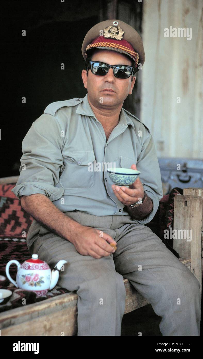 Officier afghan chargé des tâches de construction routière pendant une pause thé. Banque D'Images