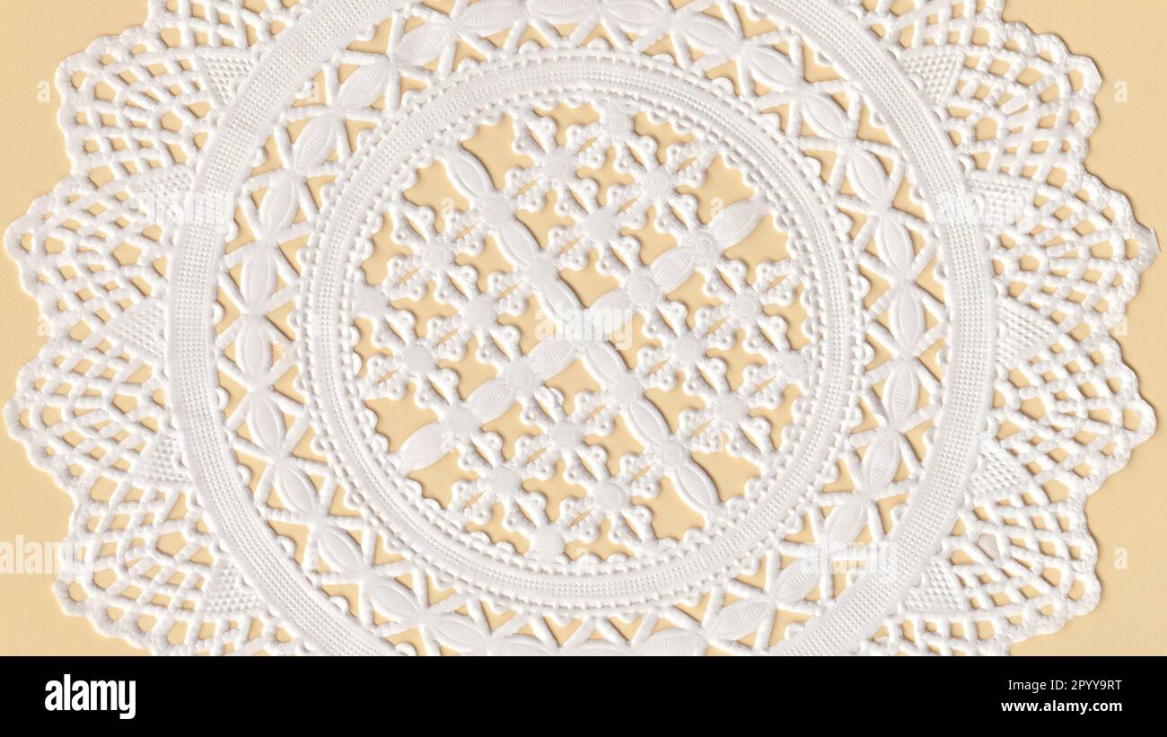 Partie d'un gâteau de tasse de papier Doily sur un papier jaune. Banque D'Images
