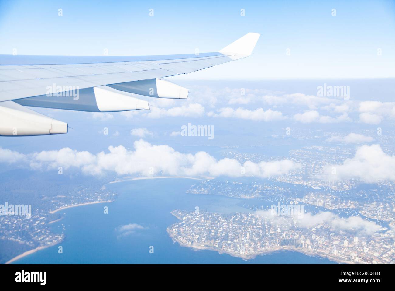 Vue de l'aile d'avion au-dessus de la ville australienne après le décollage avec les nuages et le paysage Banque D'Images