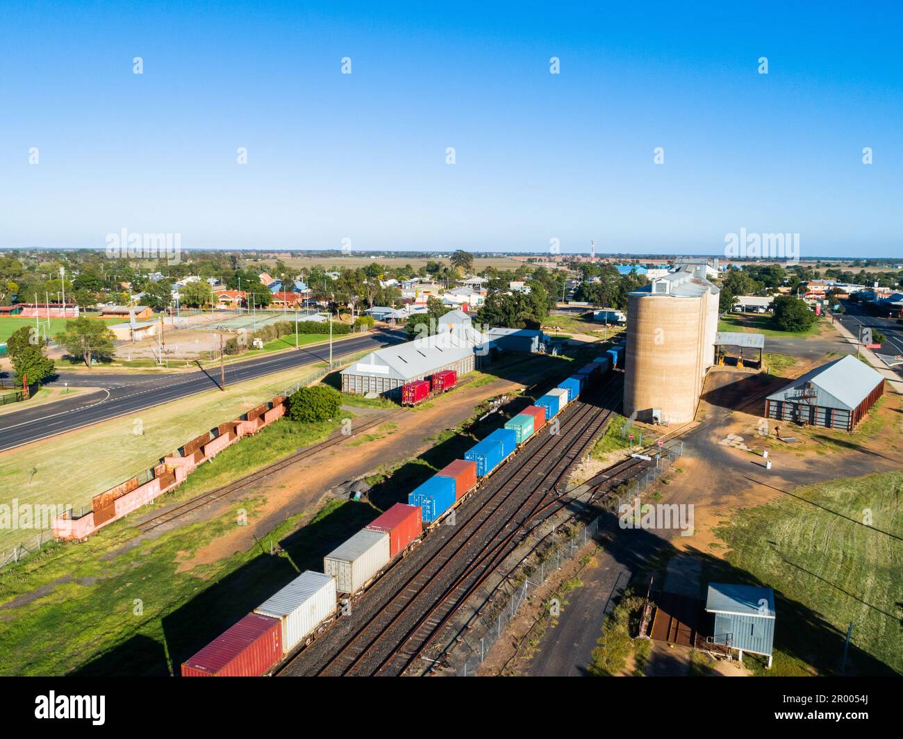 Scène aérienne de la ville de campagne australienne à Narromine de silos à grain à côté du chemin de fer et du train de marchandises le jour ensoleillé Banque D'Images