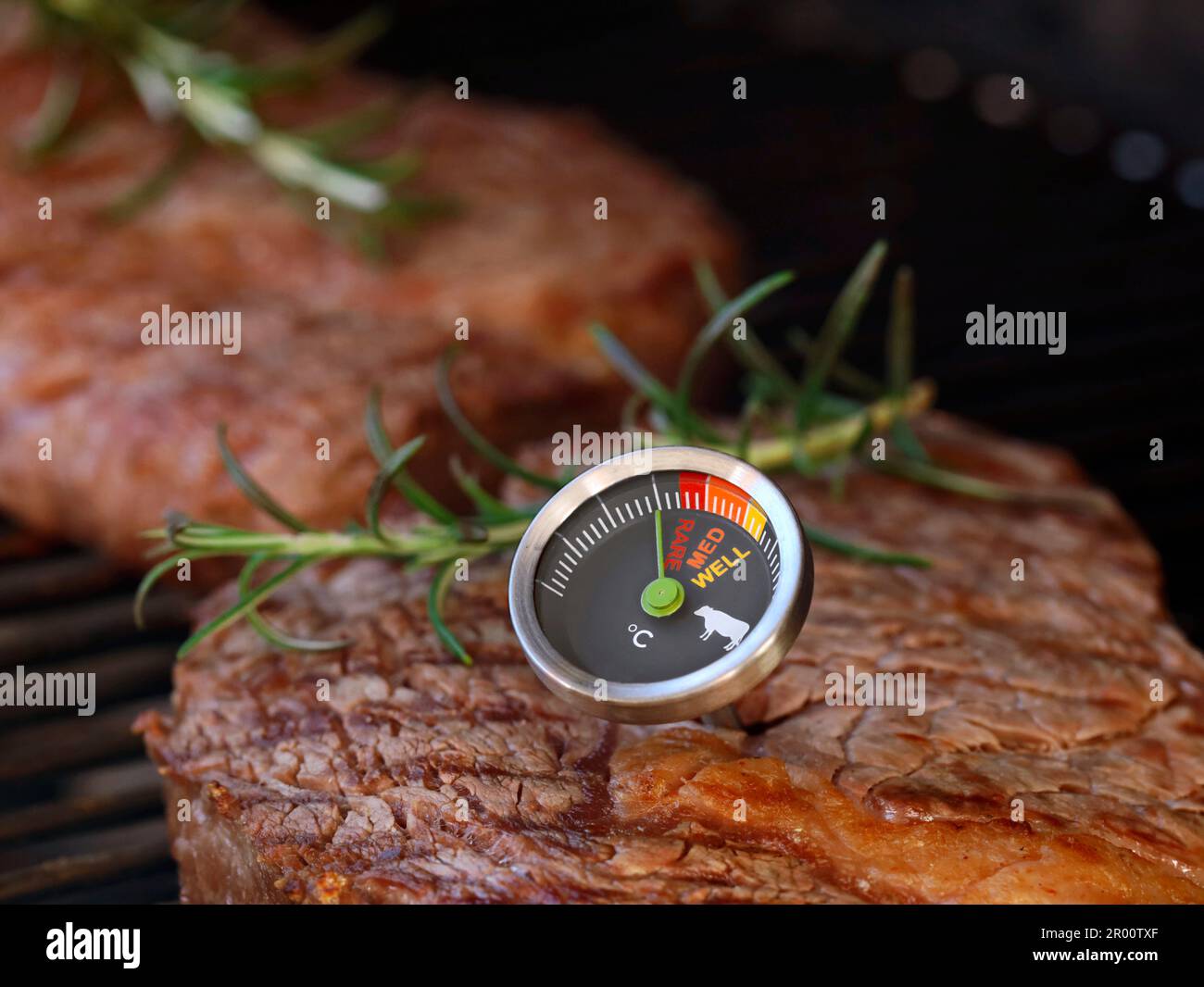 délicieux steak de boeuf sur grille avec un thermomètre à viande montrant la donuité de rare, moyen et bien fait Banque D'Images