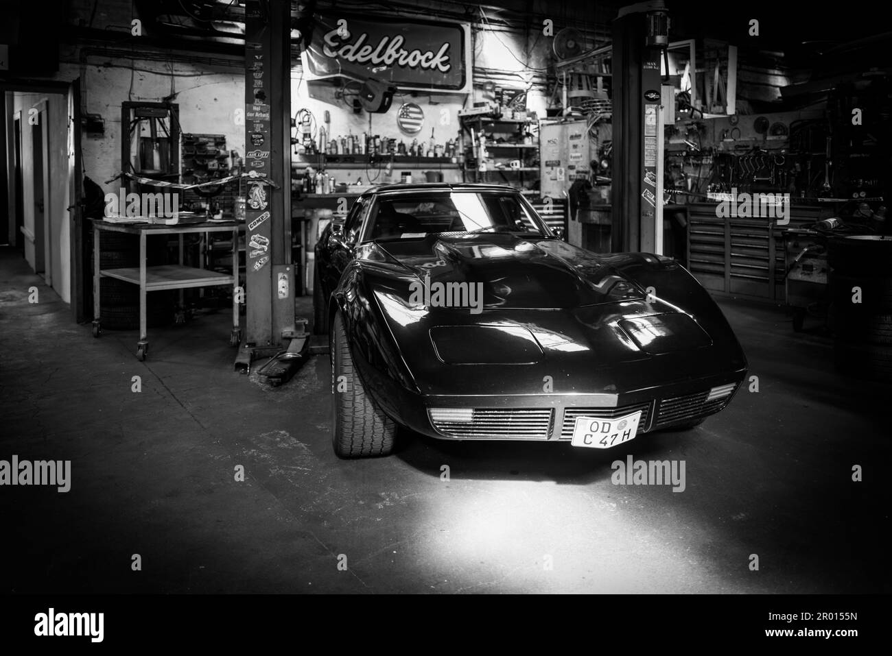 Une ancienne Corvette C3 noire se tient dans un atelier Banque D'Images