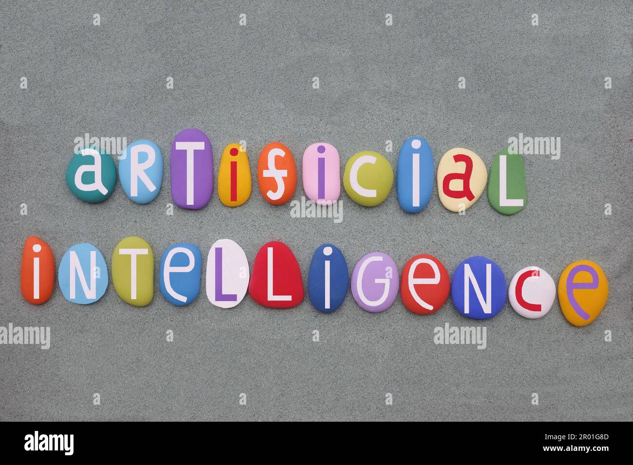 Intelligence artificielle, texte créatif composé de lettres de pierre multicolores peintes à la main sur du sable vert Banque D'Images