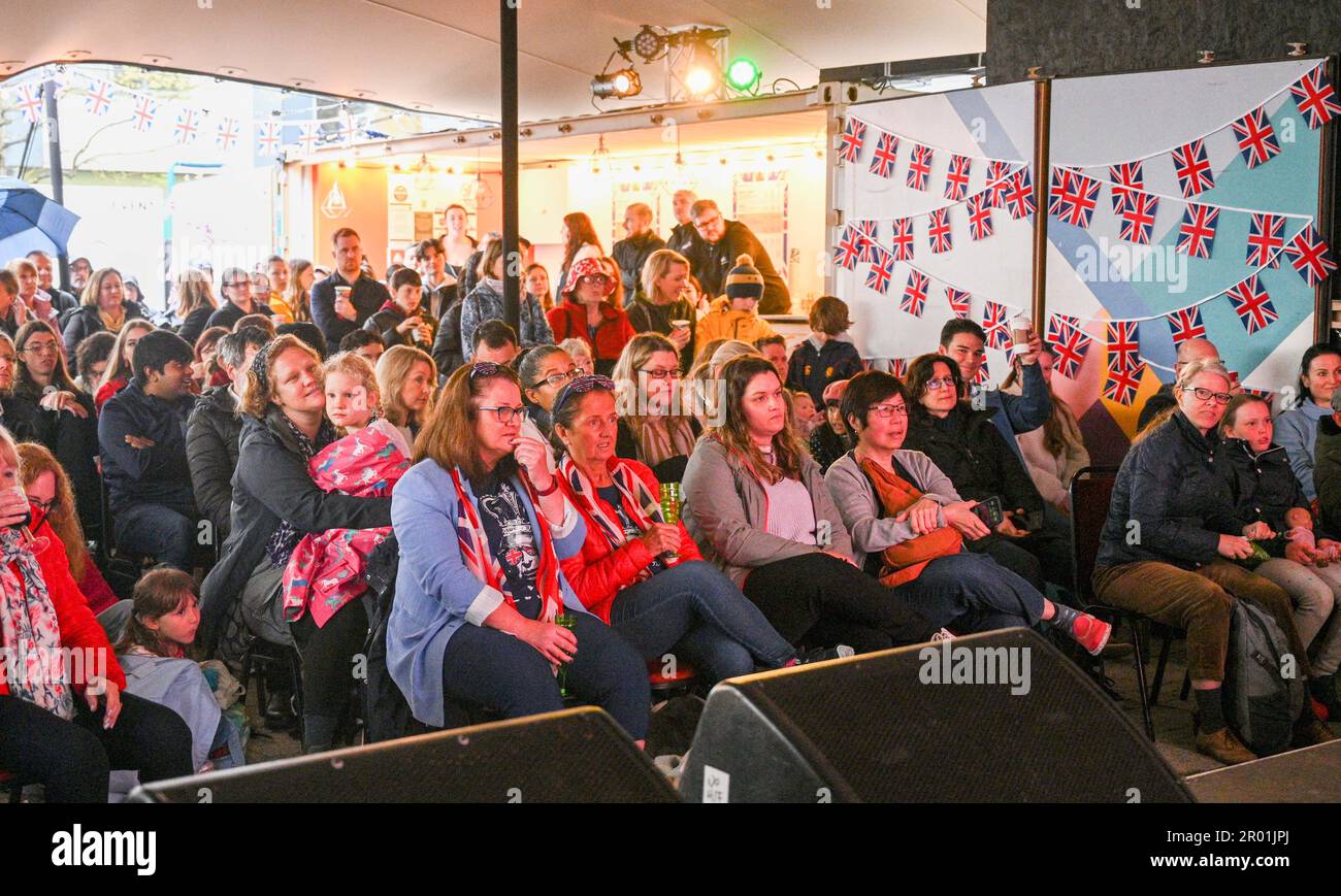 Brighton UK 6th mai 2023 - les foules regardent le couronnement du roi Charles III sur un grand écran de Brighton Jubilee Square aujourd'hui : Credit Simon Dack / Alamy Live News Banque D'Images