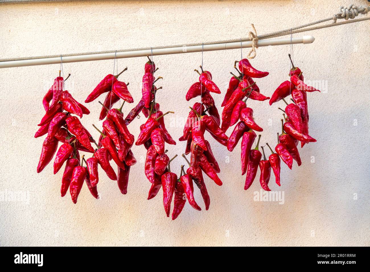 Piments de piment séchant au soleil sur un mur à Pianella, Italie Banque D'Images