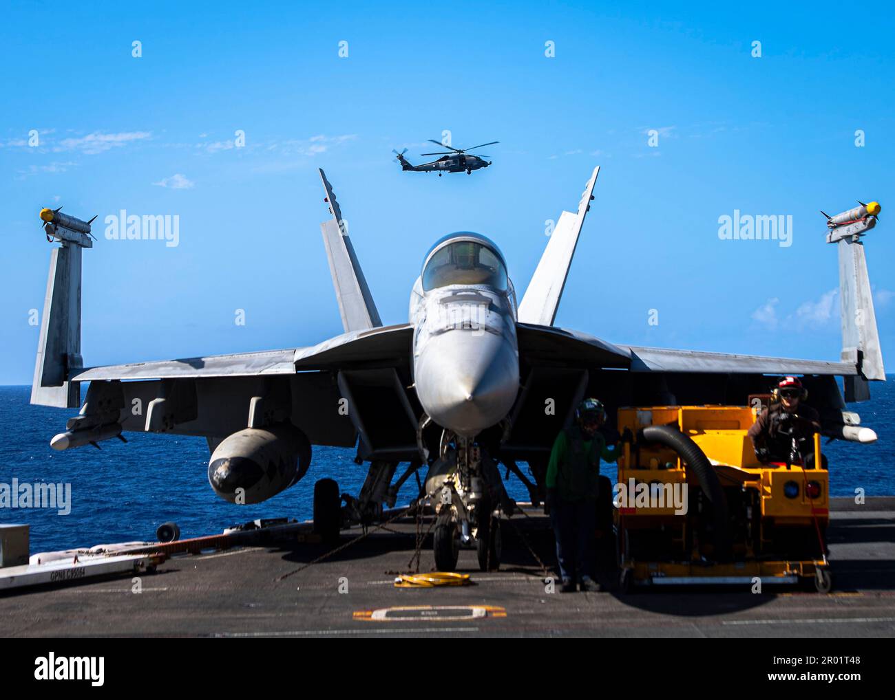 USS Nimitz, eaux internationales. 04 mai 2023. A ÉTATS-UNIS L'hélicoptère Sea Hawk MH-60R de la Marine, provenant des Battlecats de l'escadron de frappe maritime 73, survole un avion de chasse Super Hornet F/A-18E sur le pont de vol du porte-avions de la classe Nimitz USS Nimitz, en cours d'exécution d'opérations de routine, 4 mai 2023 en mer des Philippines. Crédit : MC2 Joseph Calabre/U.S. Navy photo/Alay Live News Banque D'Images