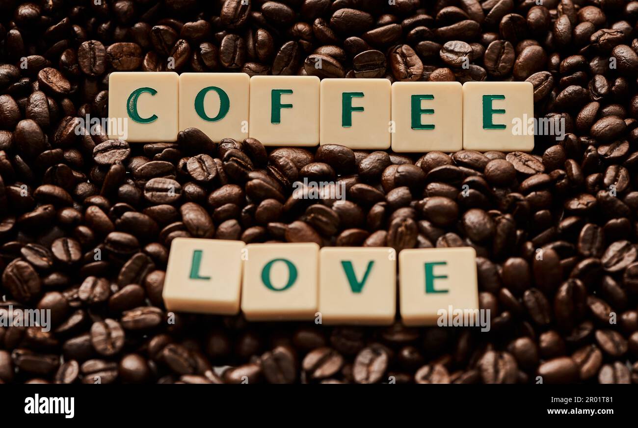 Le café est mon seul vrai amour. Gros plan de lettres en bloc formant les mots amour du café sur une pile de grains de café. Banque D'Images