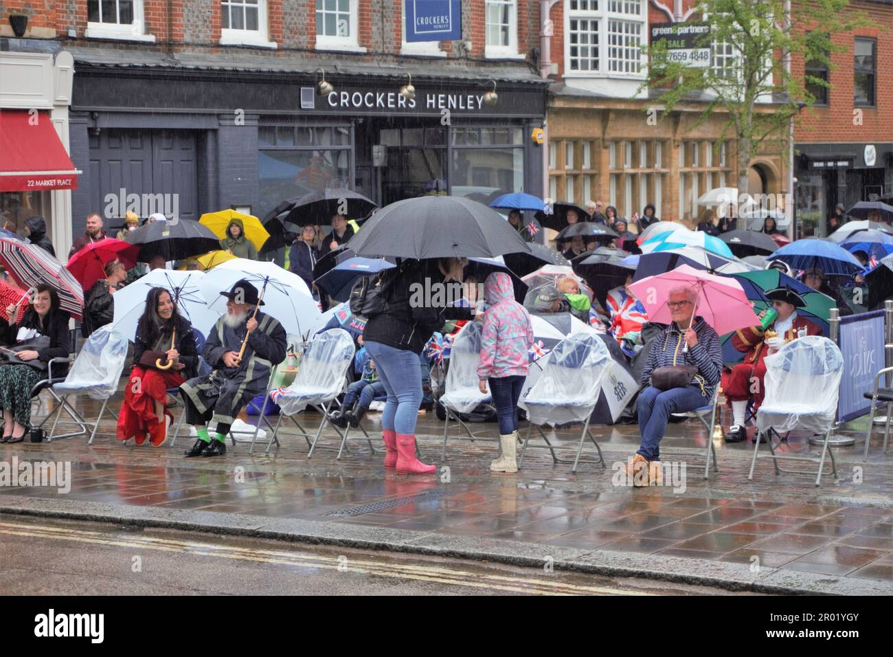 Henley-on-Thames, Royaume-Uni. 6th mai 2023. Les spectateurs brave la pluie pour regarder le couronnement du roi Charles III sur un grand écran sur le marché. Credit: Uwe Deffner/Alay Live News Banque D'Images