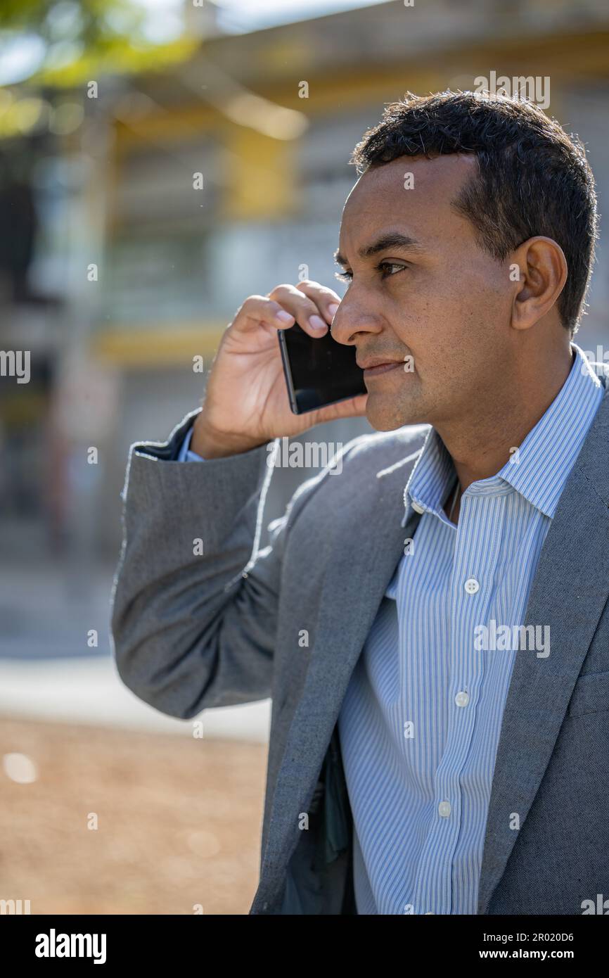 Photo moyenne d'un jeune latino parlant au téléphone. Banque D'Images