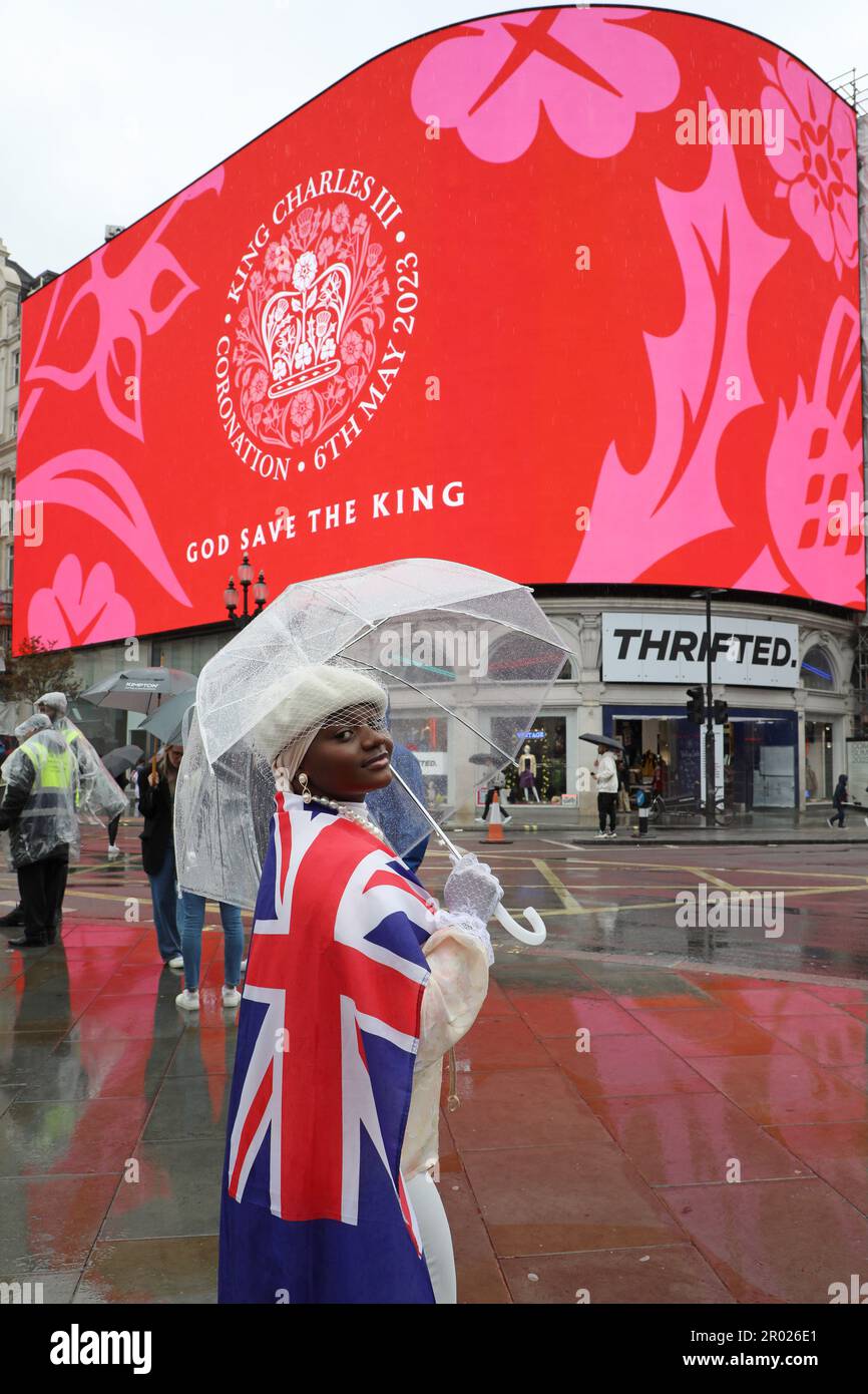 Londres, Royaume-Uni. 6th mai 2023. Supporter portant le drapeau rouge, blanc et bleu de Union Jack regardant le message de Coronation pour le couronnement du roi Charles III, à Piccadilly Circus, Londres dire heureux et glorieux et Dieu sauver le roi crédit: Paul Brown/Alay Live News Banque D'Images